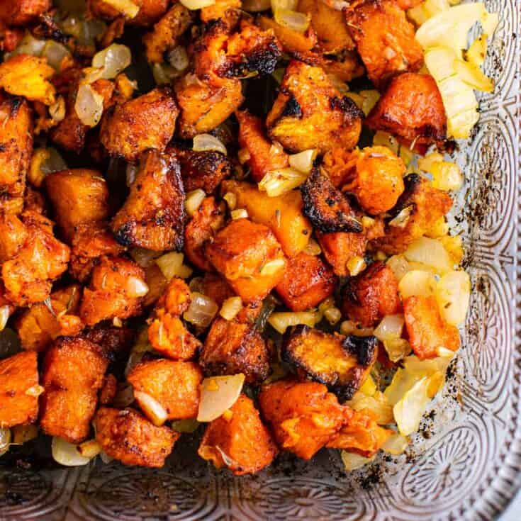 sweet potatoes diced up with onion in a glass baking dish