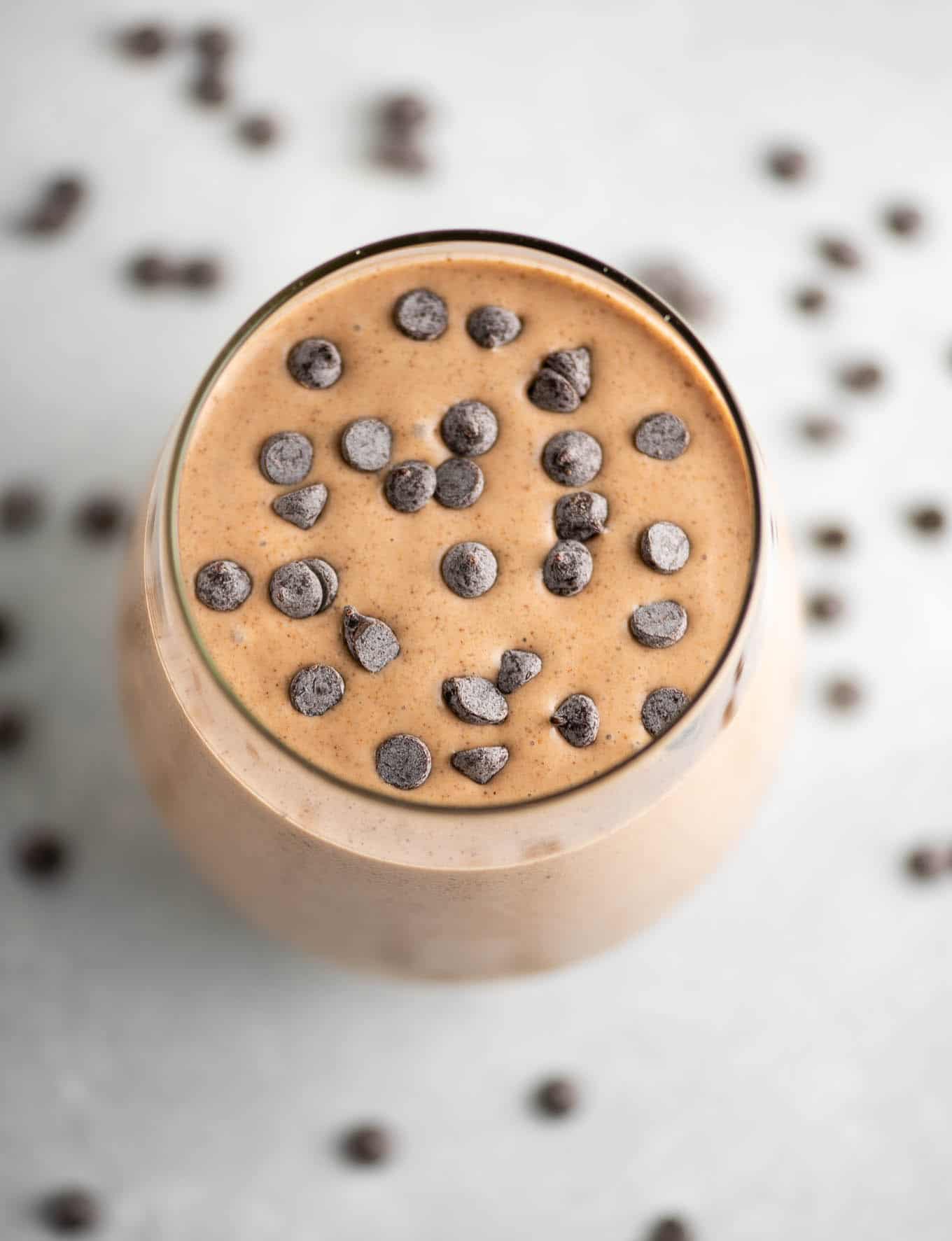 chocolate smoothie in a glass topped with mini chocolate chips