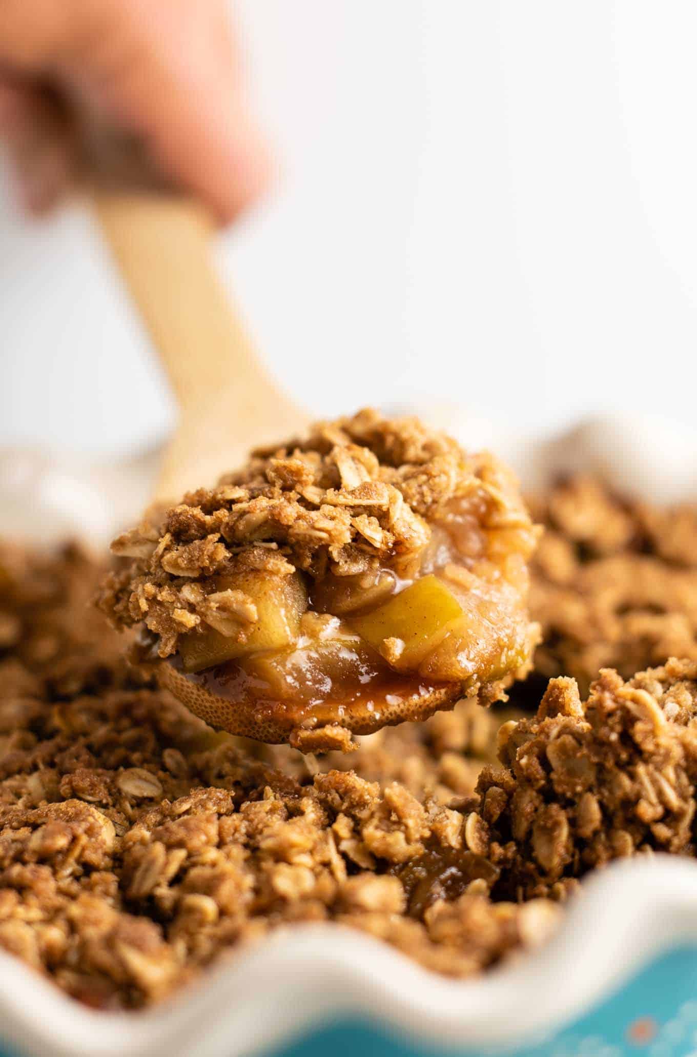 wooden spoon with a scoop of gluten free apple crisp