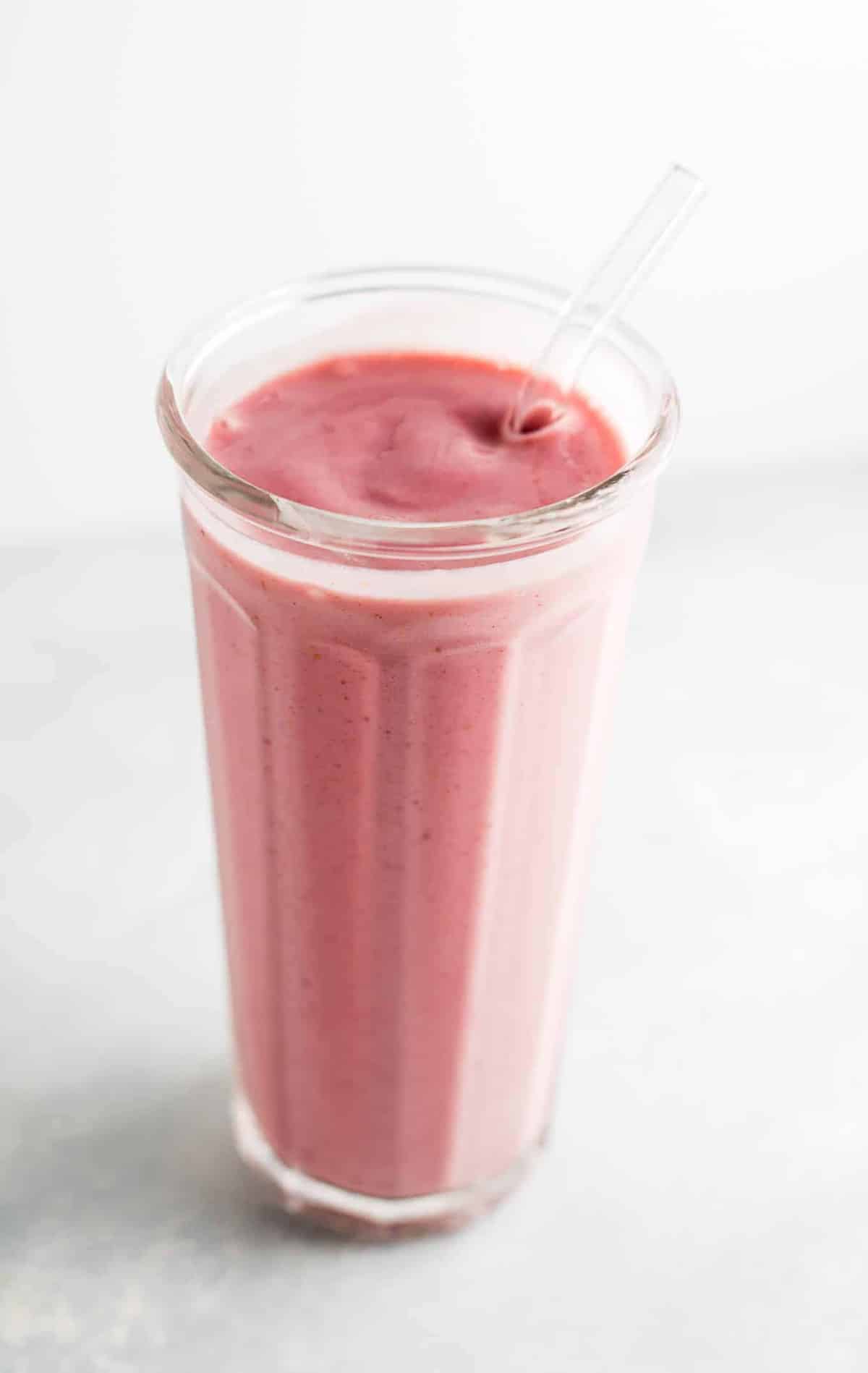 strawberry banana yogurt smoothie in a glass with a straw