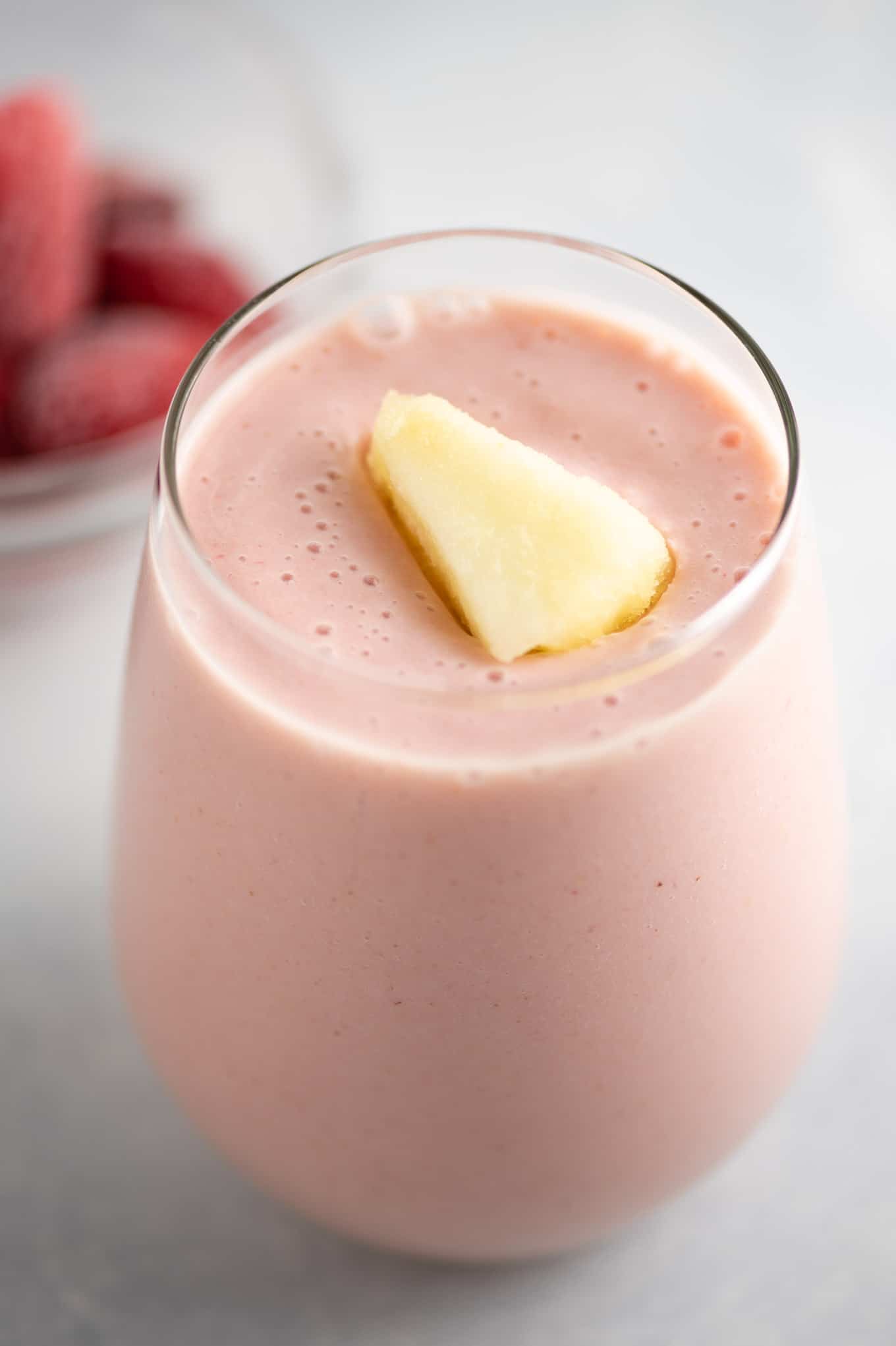 strawberry and pineapple smoothie with frozen pineapple on top