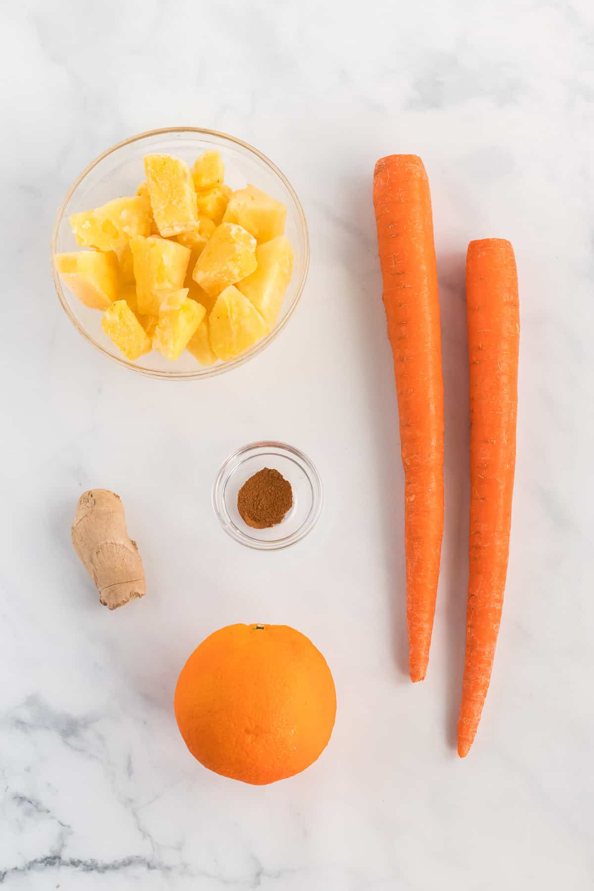 carrots, frozen pineapple, ginger, cinnamon, and an orange