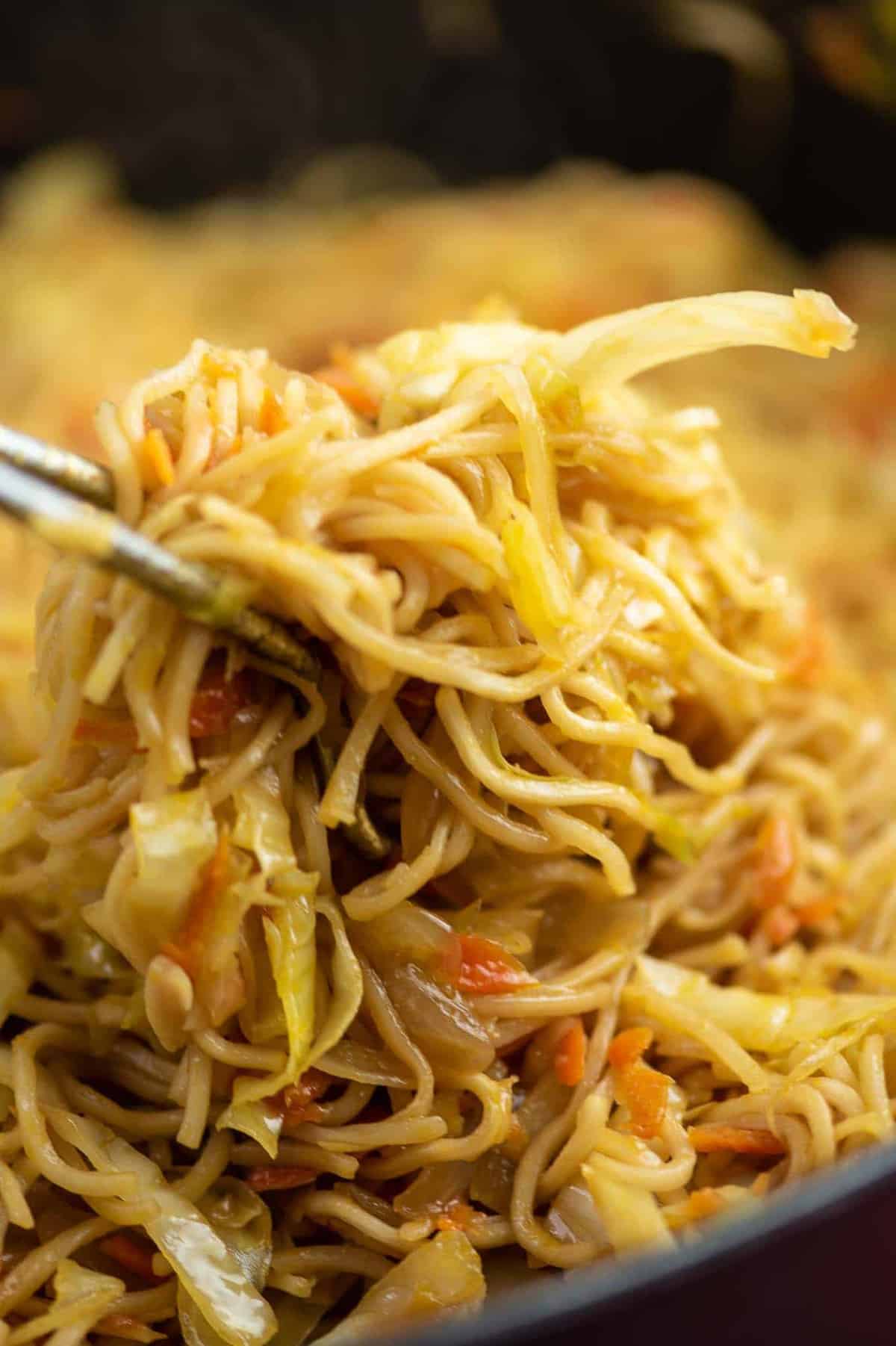 cabbage stir fry being pulled from a pan with tongs