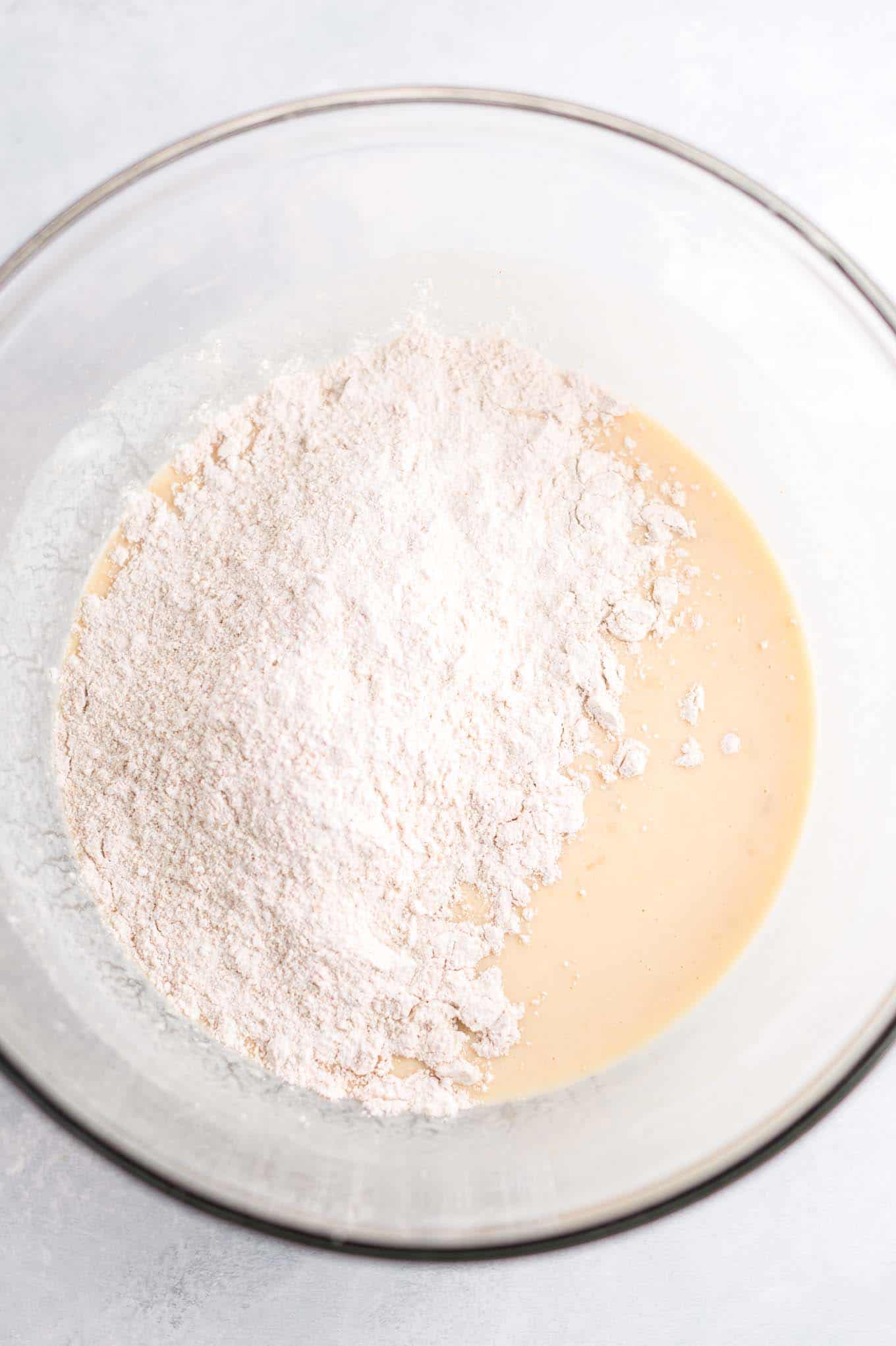 Flour and wet muffin ingredients in a mixing bowl