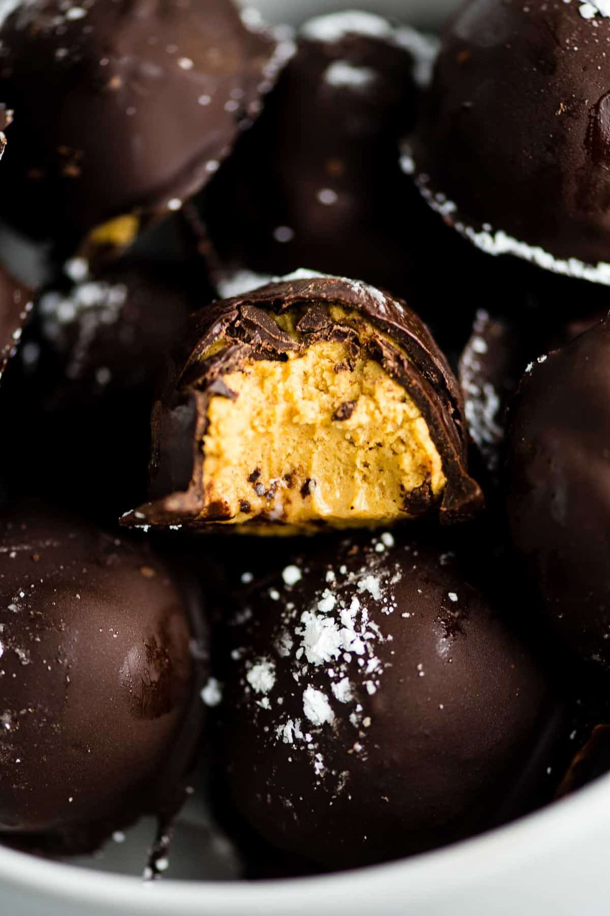 dark chocolate pumpkin truffle with a bite taken out