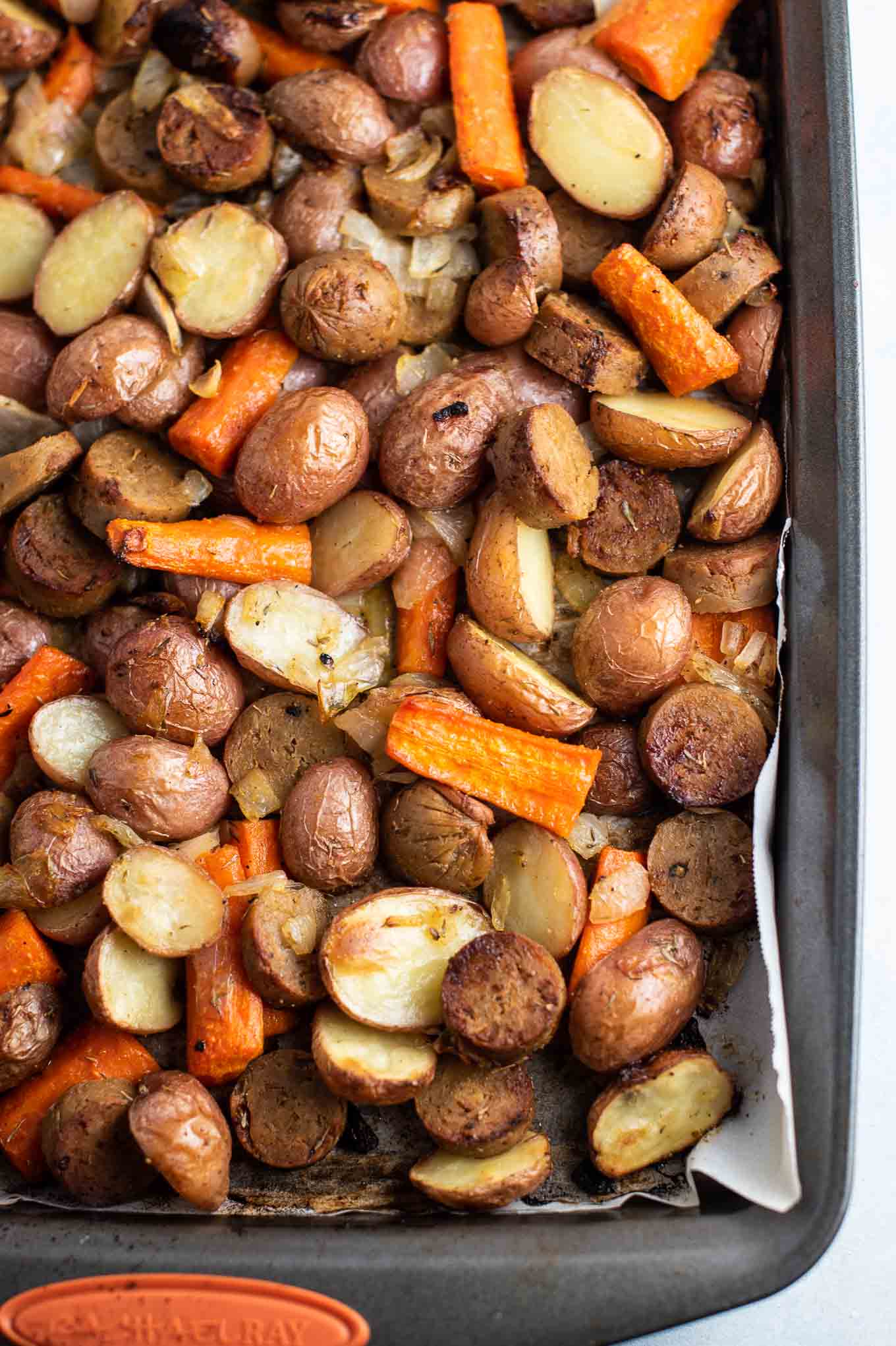 sheet pan with roasted vegetarian kielbasa, carrots, potatoes, and onions