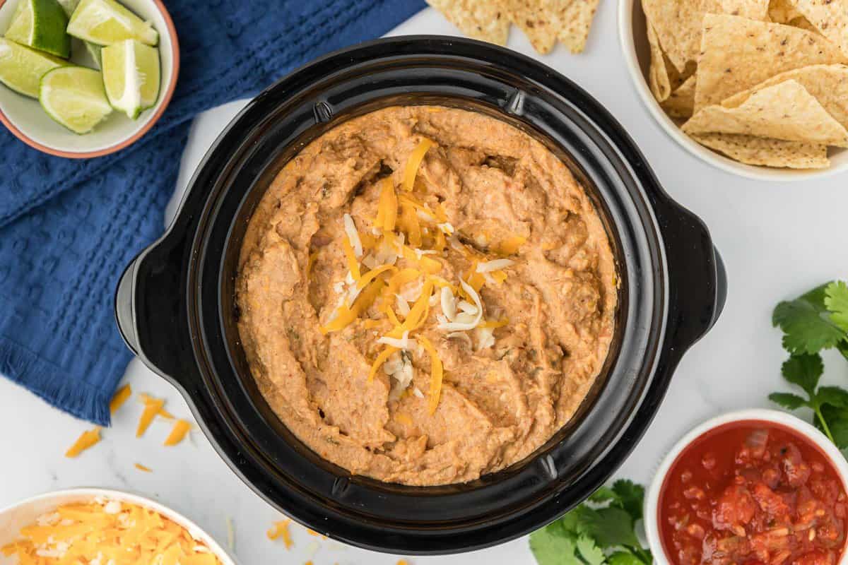 bean dip in a crock pot topped with cheese