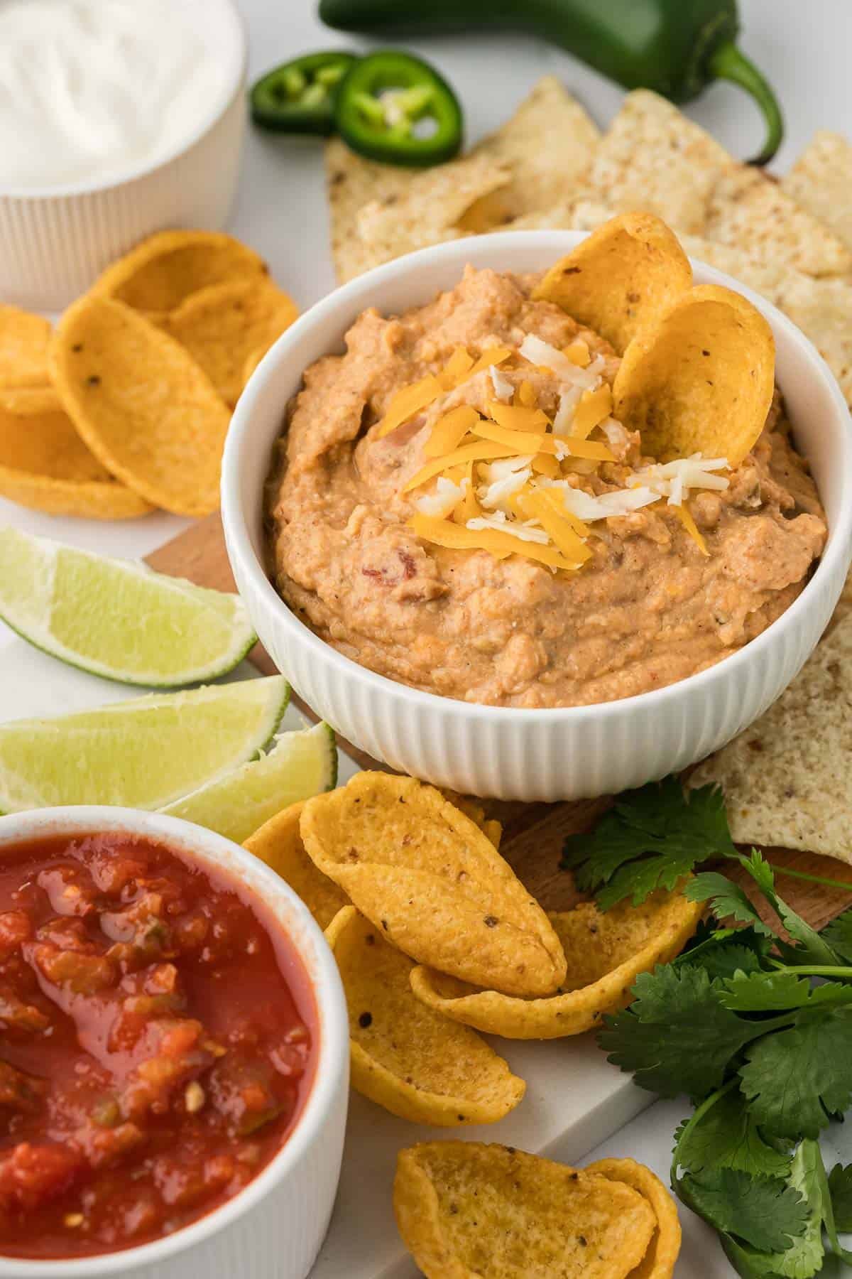 bean dip in a white bowl with tortilla chips