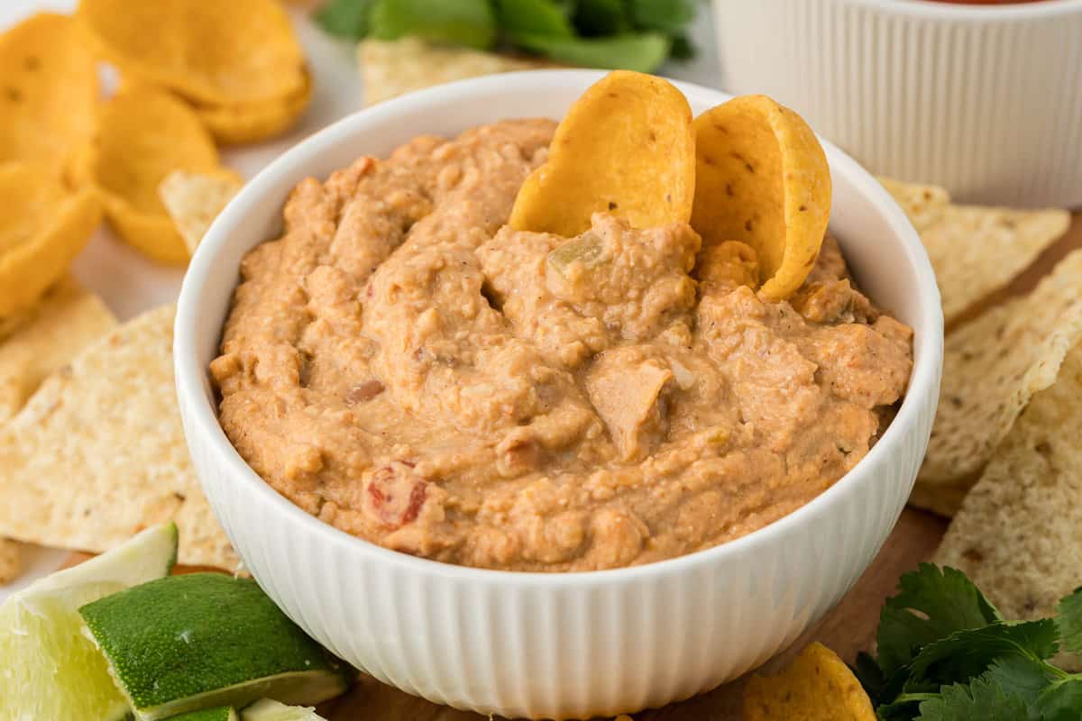 bean dip in a white bowl with tortilla chips