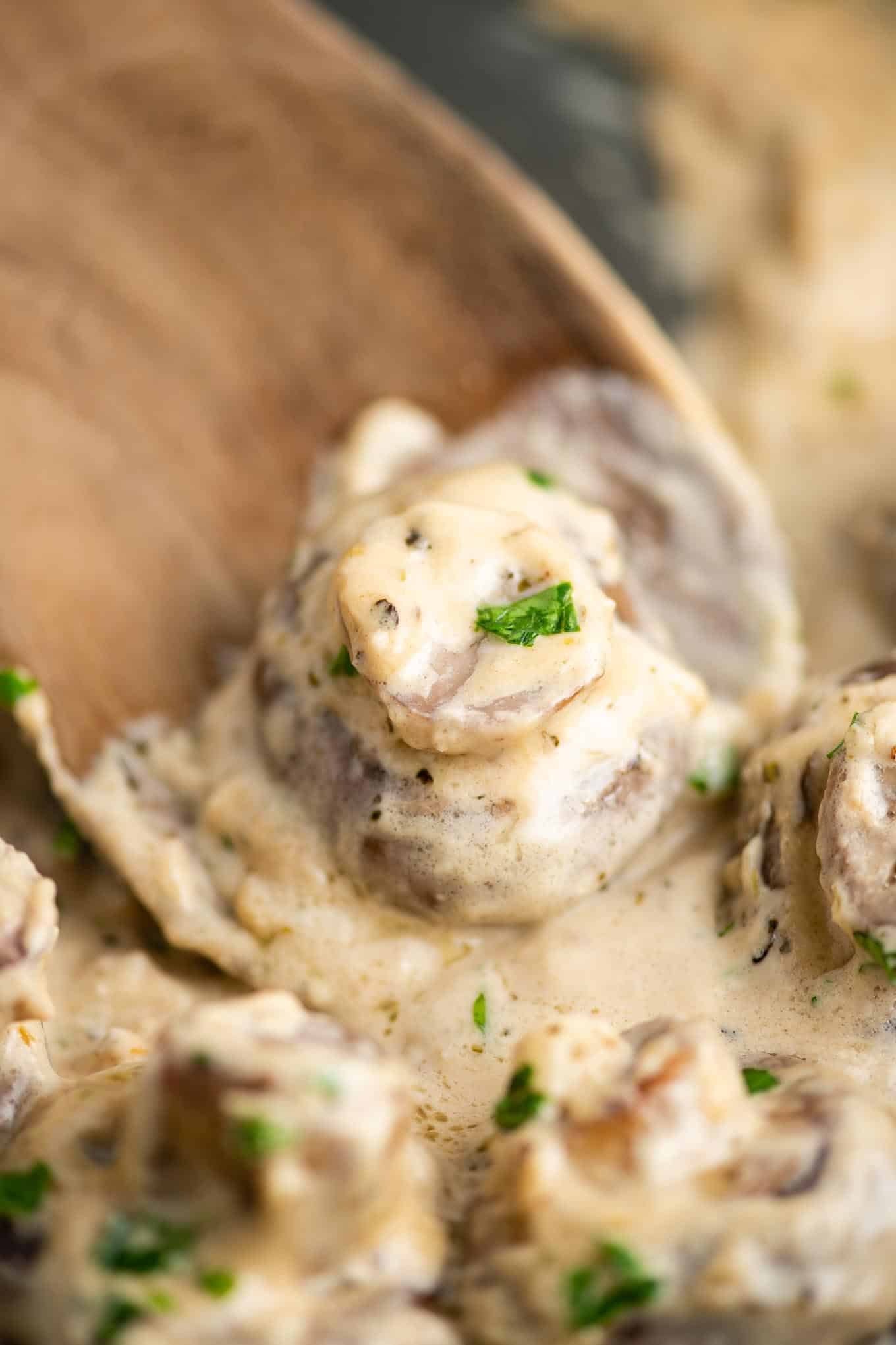 wooden spoon with a creamy garlic mushroom