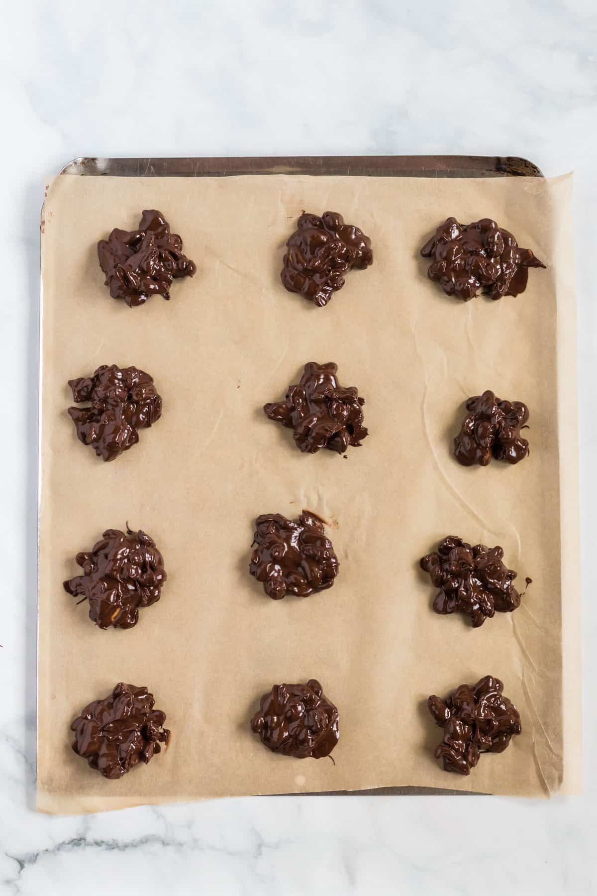 peanut clusters on a parchment paper lined baking sheet