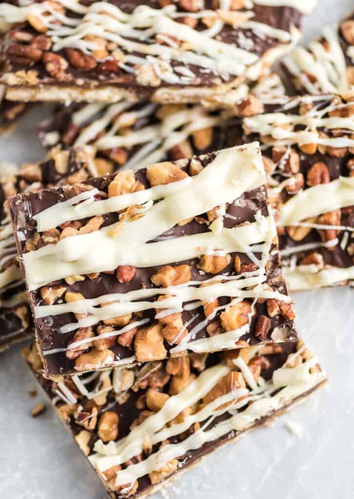 christmas crack topped with walnuts, pecans, and drizzled white chocolate