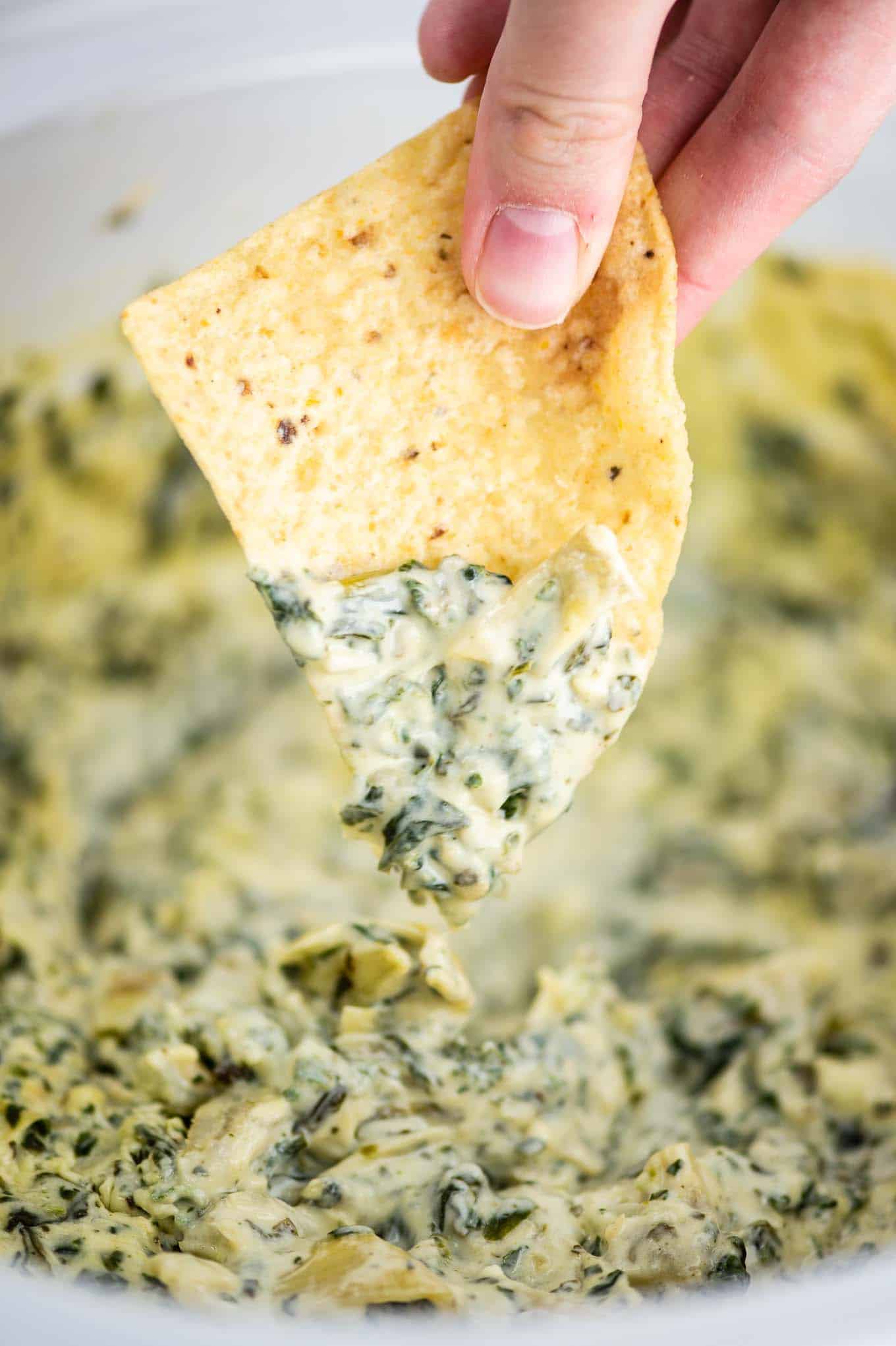 up close image of a bite of spinach artichoke dip