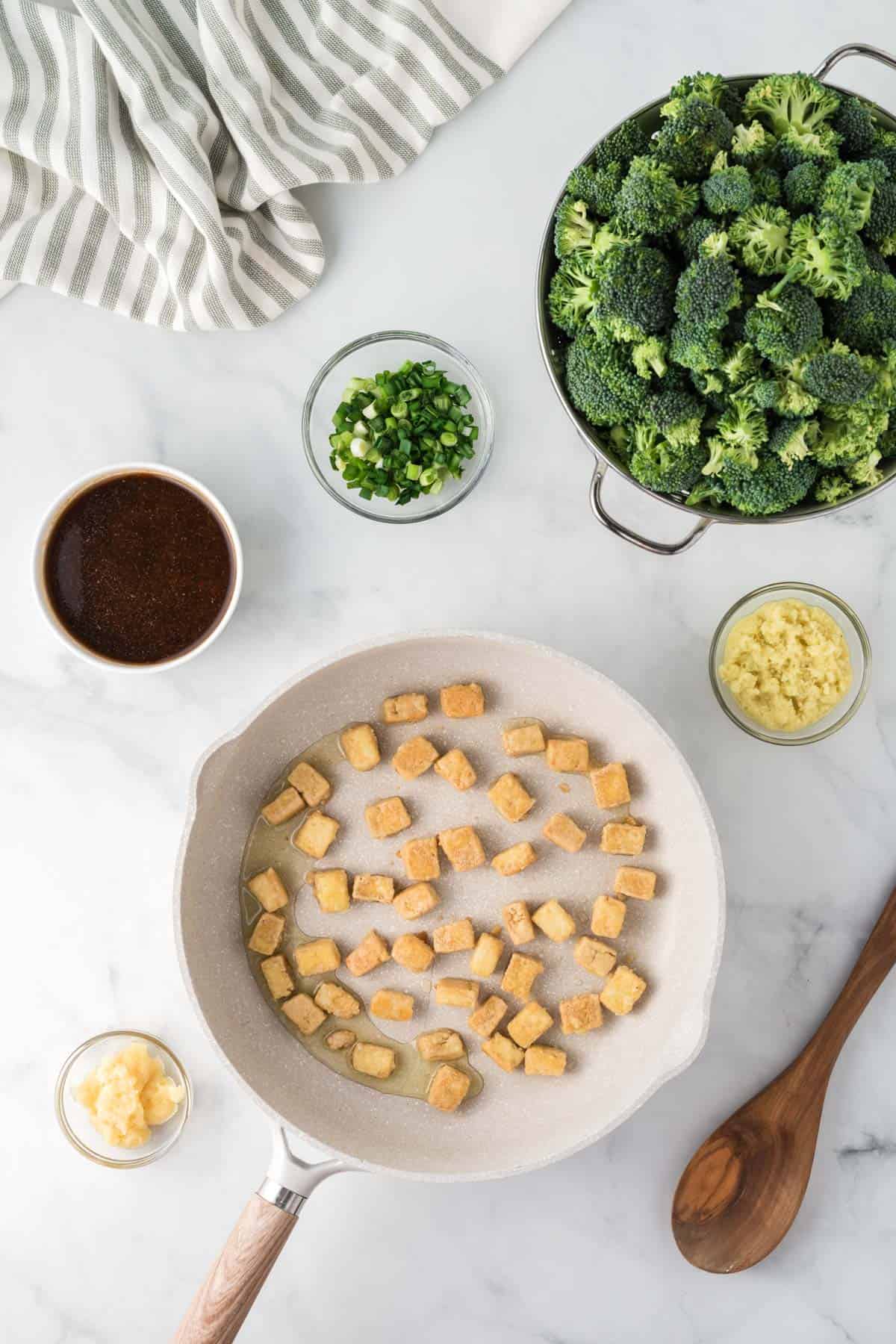 cooked tofu in the skillet surrounded by the recipe ingredients