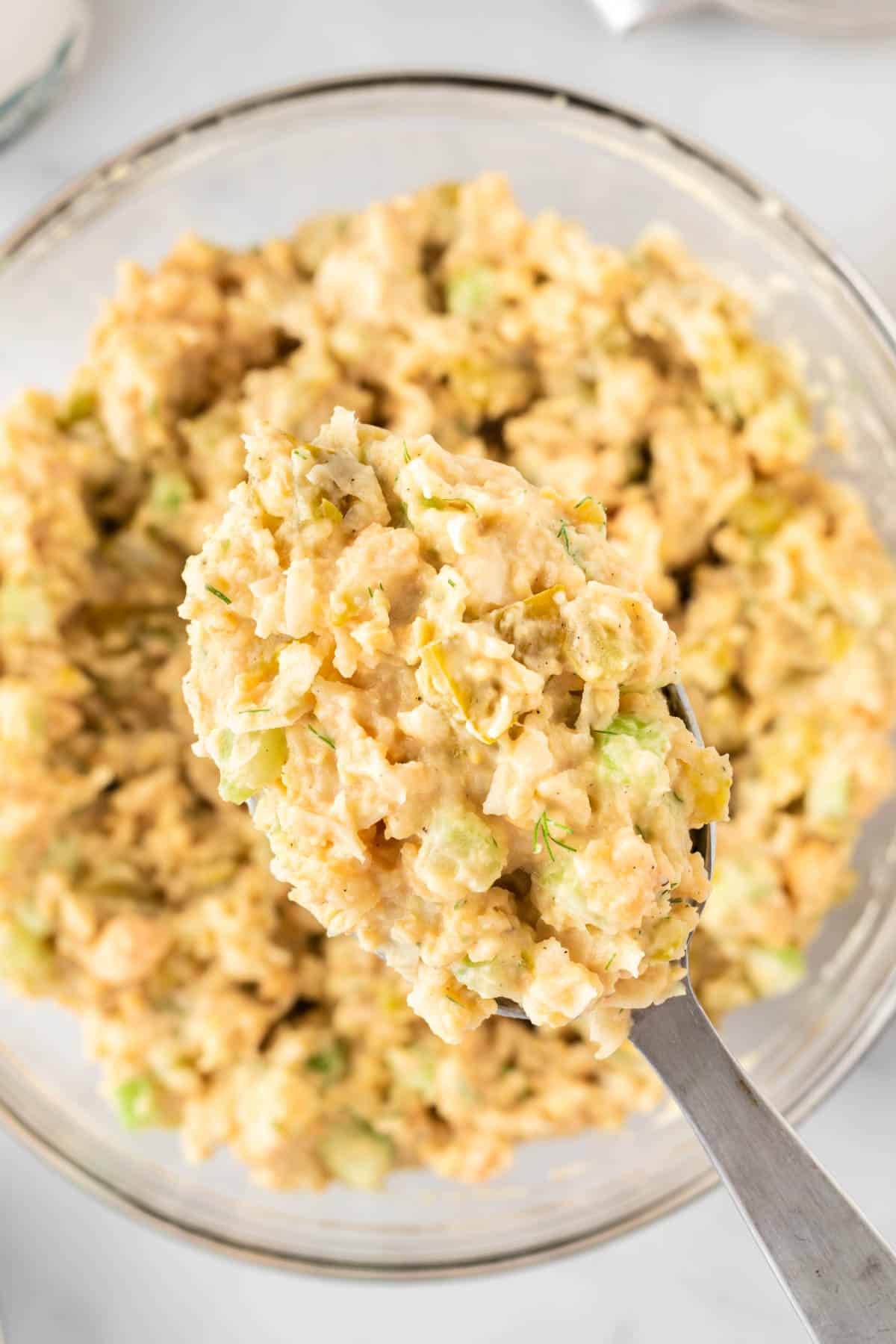 spoon taking a scoop of chickpea salad from the bowl