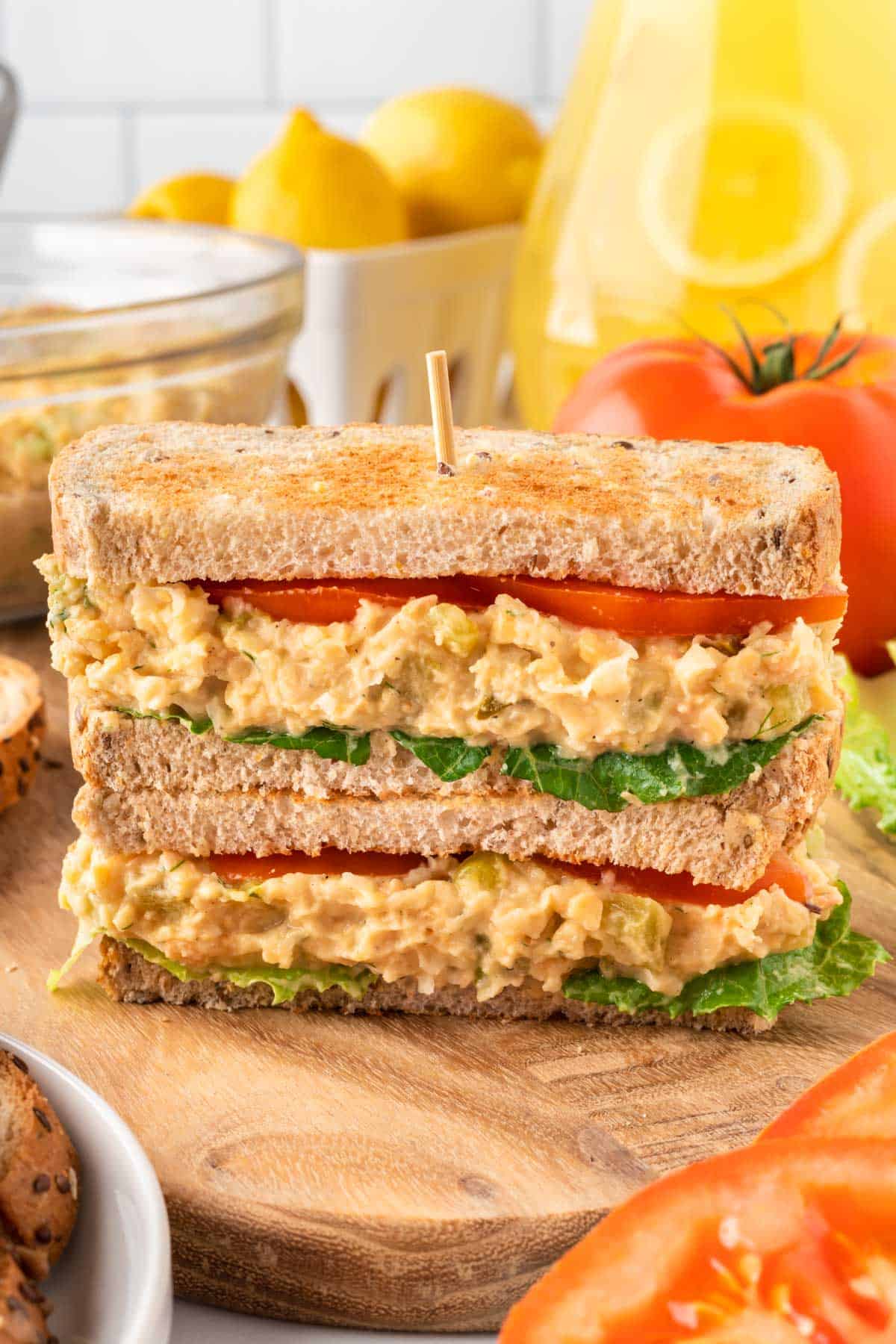 chickpea salad sandwich on bread with tomato and lettuce