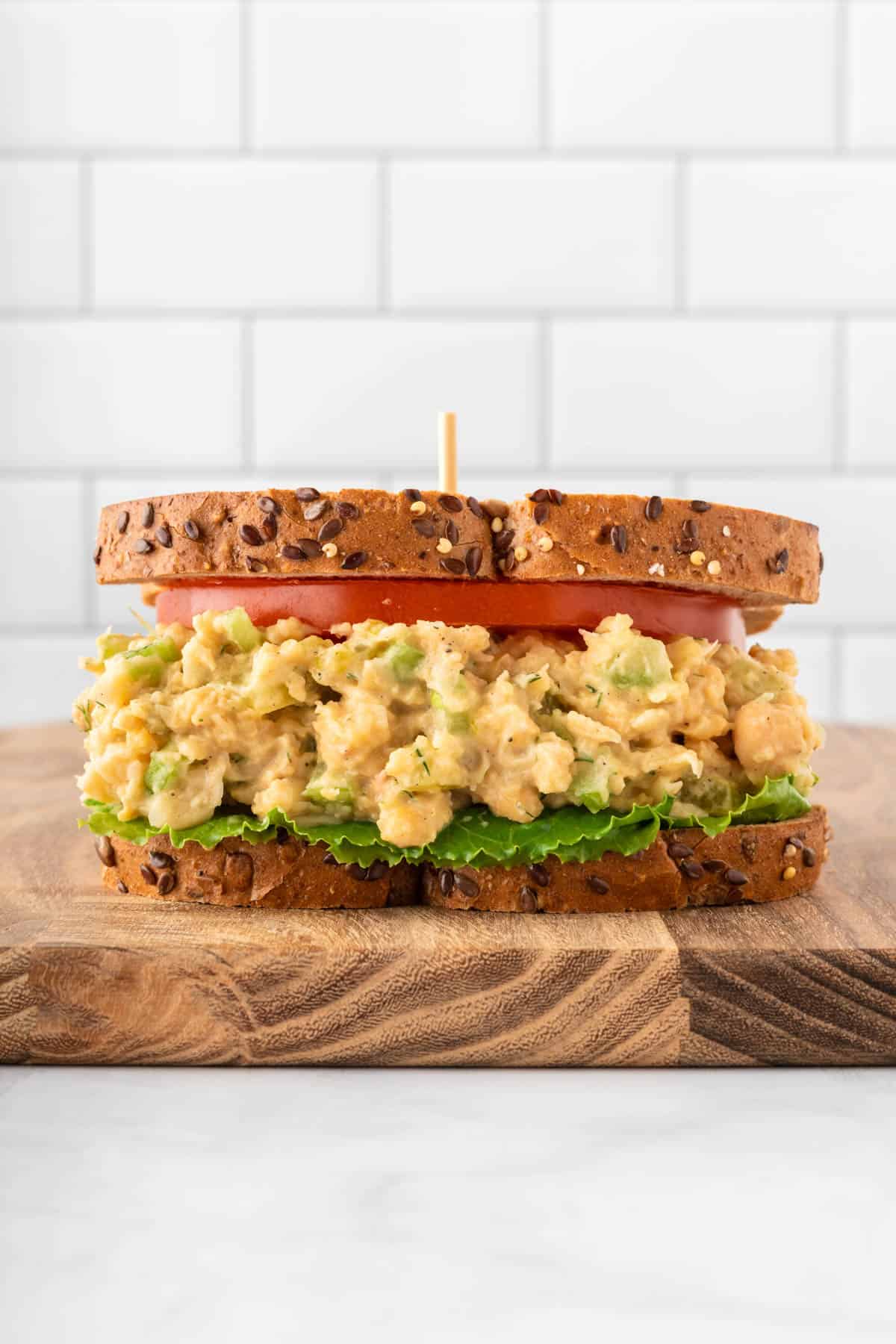 chickpea salad sandwich on bread with tomato and lettuce