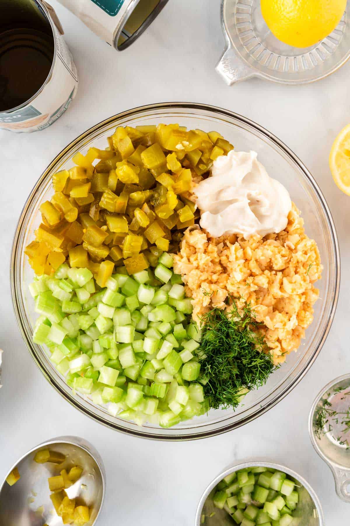 adding the celery, mayo, pickles, and dill to the chickpeas