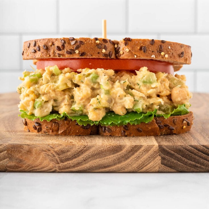 chickpea salad sandwich on bread with tomato and lettuce