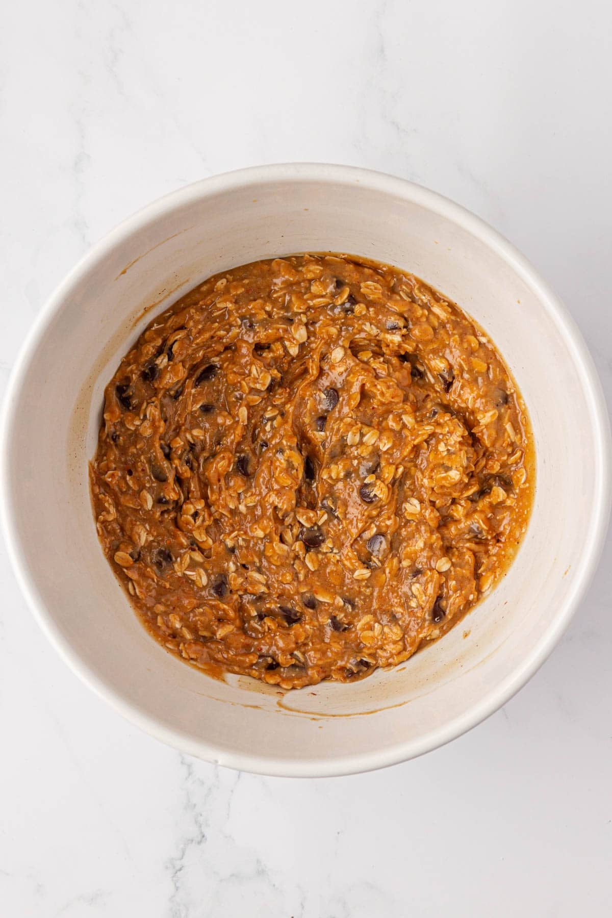 flourless peanut butter oatmeal chocolate chip cookie batter in a mixing bowl