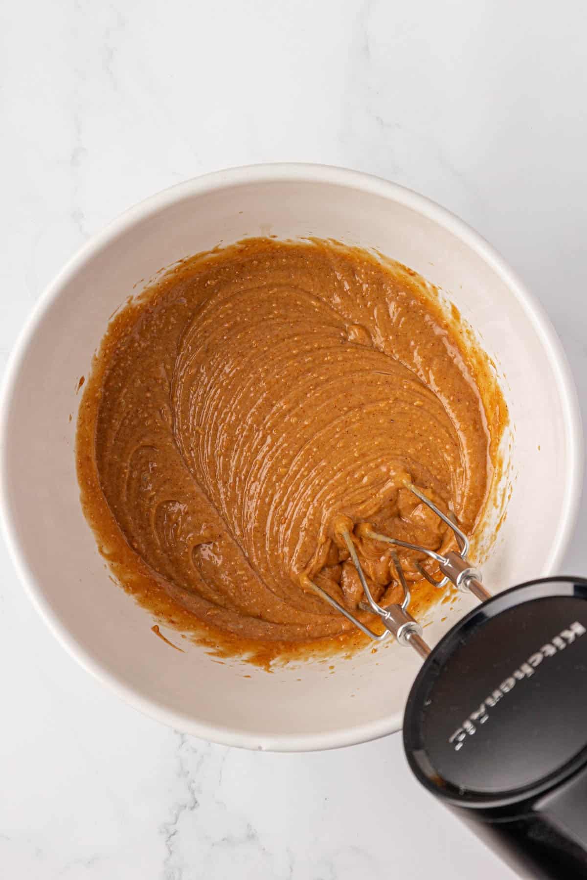 peanut butter, eggs, and maple syrup mixed together in a bowl