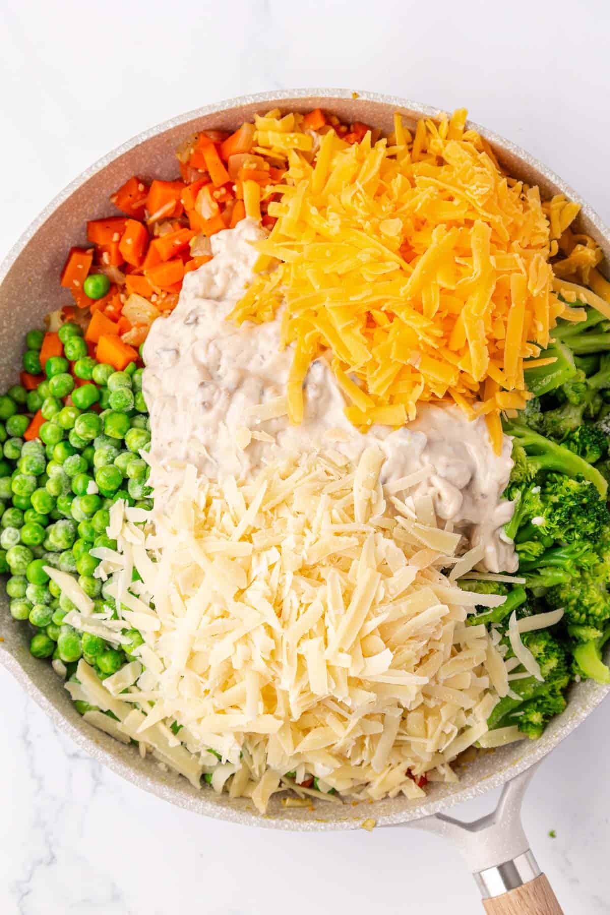 adding the cream of mushroom soup and cheese to the skillet