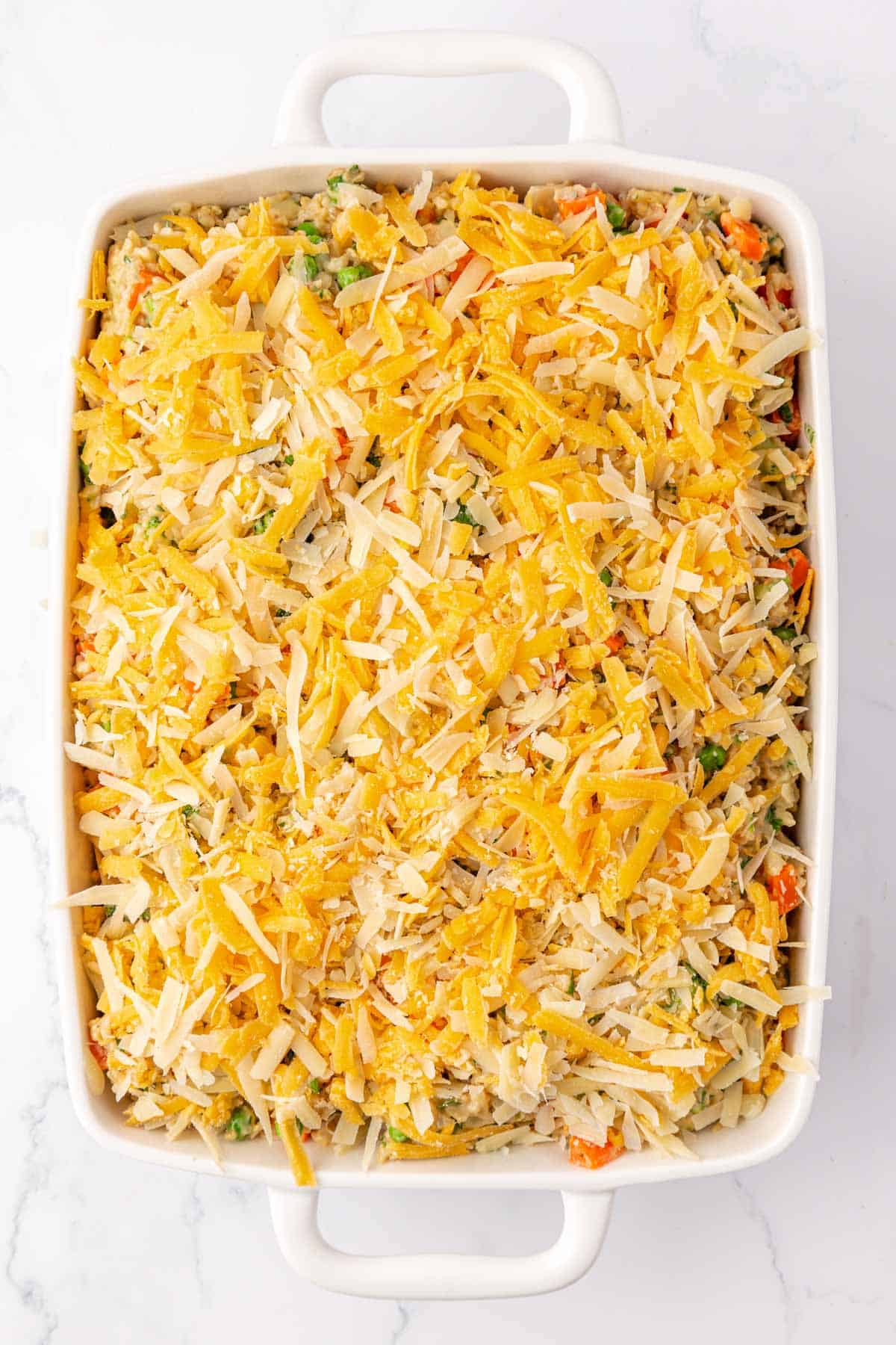 topping the vegetable rice casserole with cheese