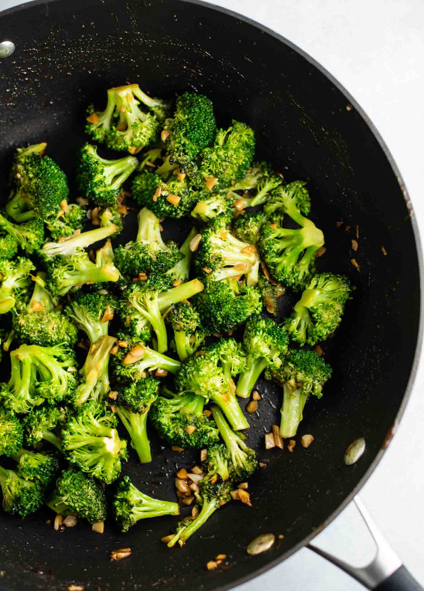 broccoli, garlic, and ginger in a skillet from an overhead view