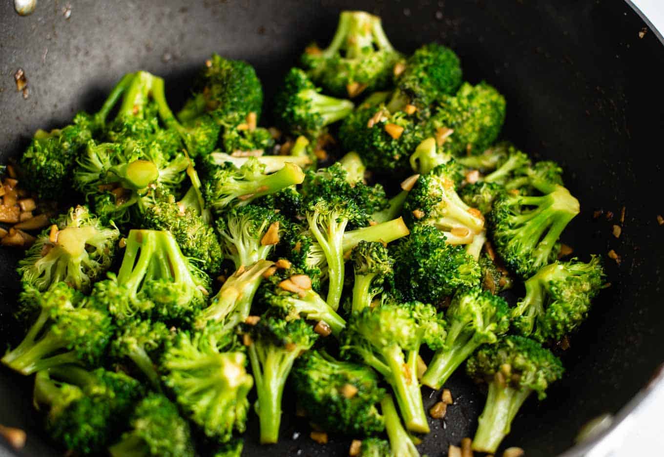 broccoli florets cooked in a black wok