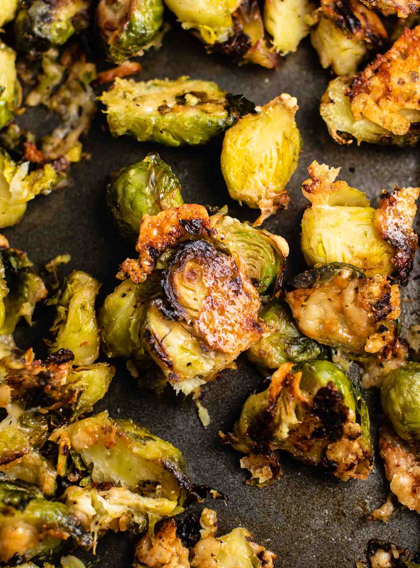 roasted frozen brussel sprouts on a black baking sheet