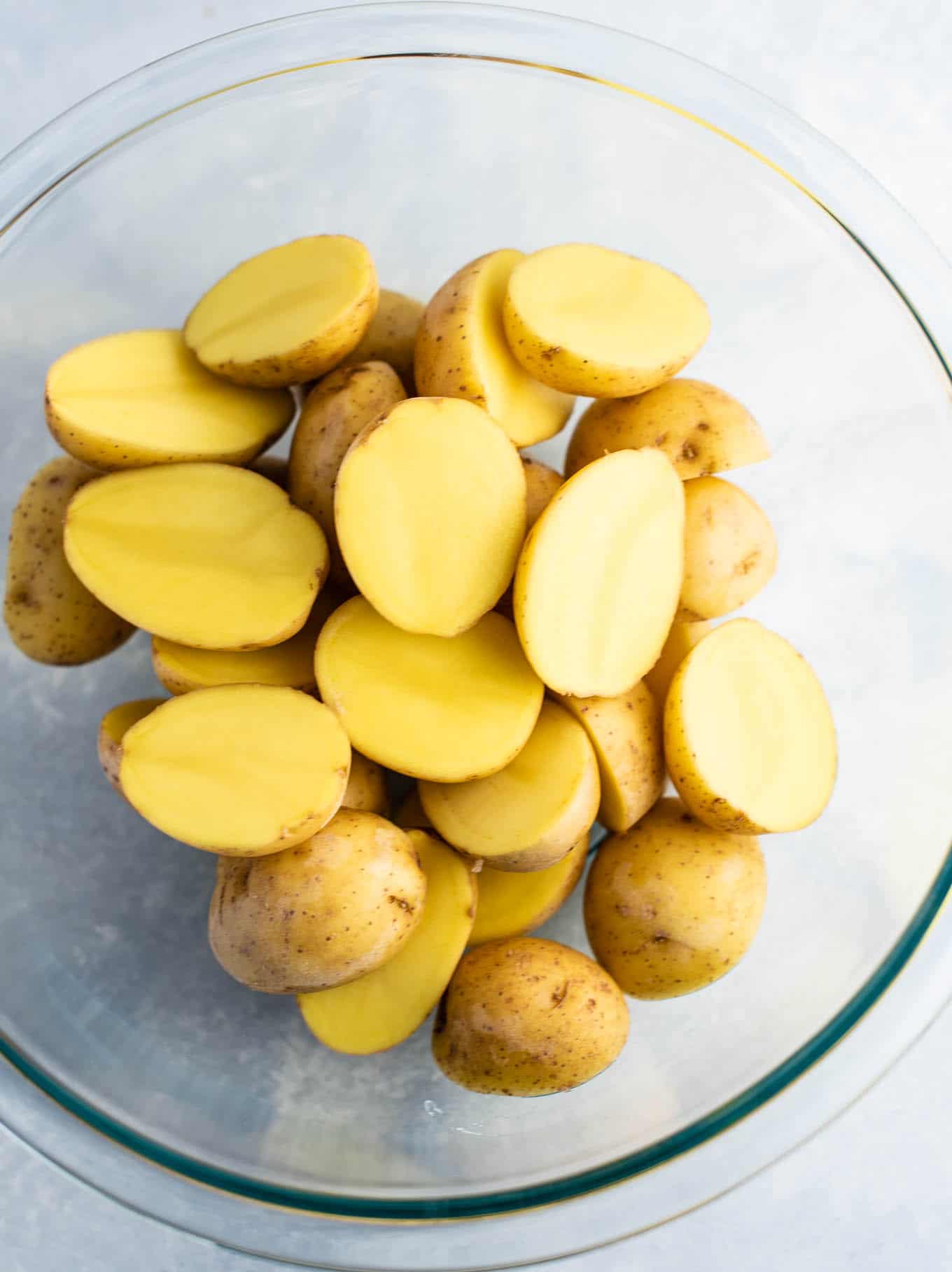 baby gold potatoes cut in half in a bowl from an overhead view