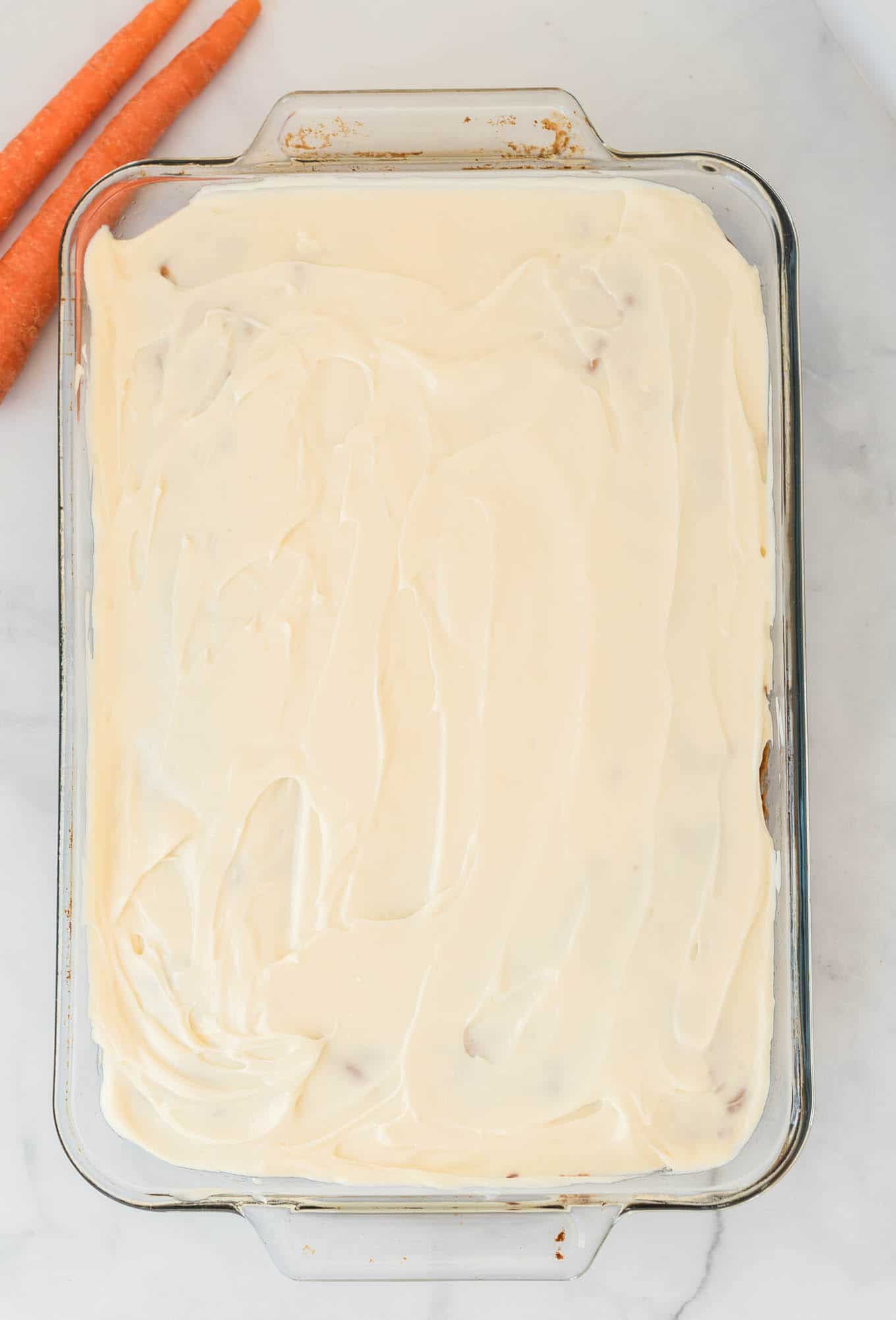 frosted gluten free carrot cake in a 9 by 13 baking dish