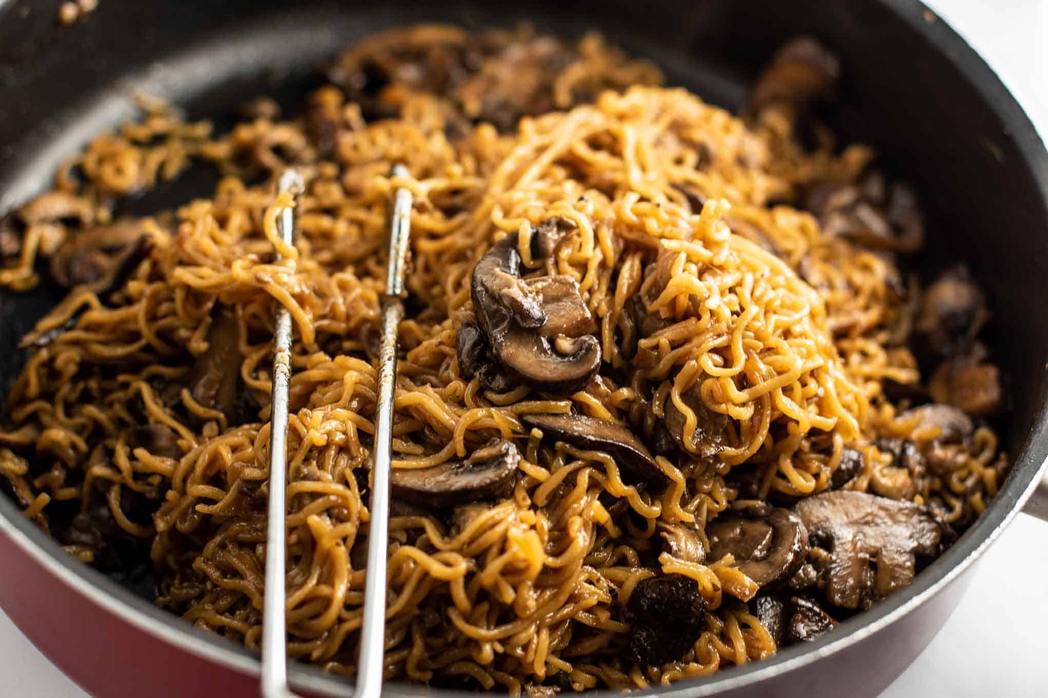 ramen noodles with mushrooms in a red jumbo cooker pan