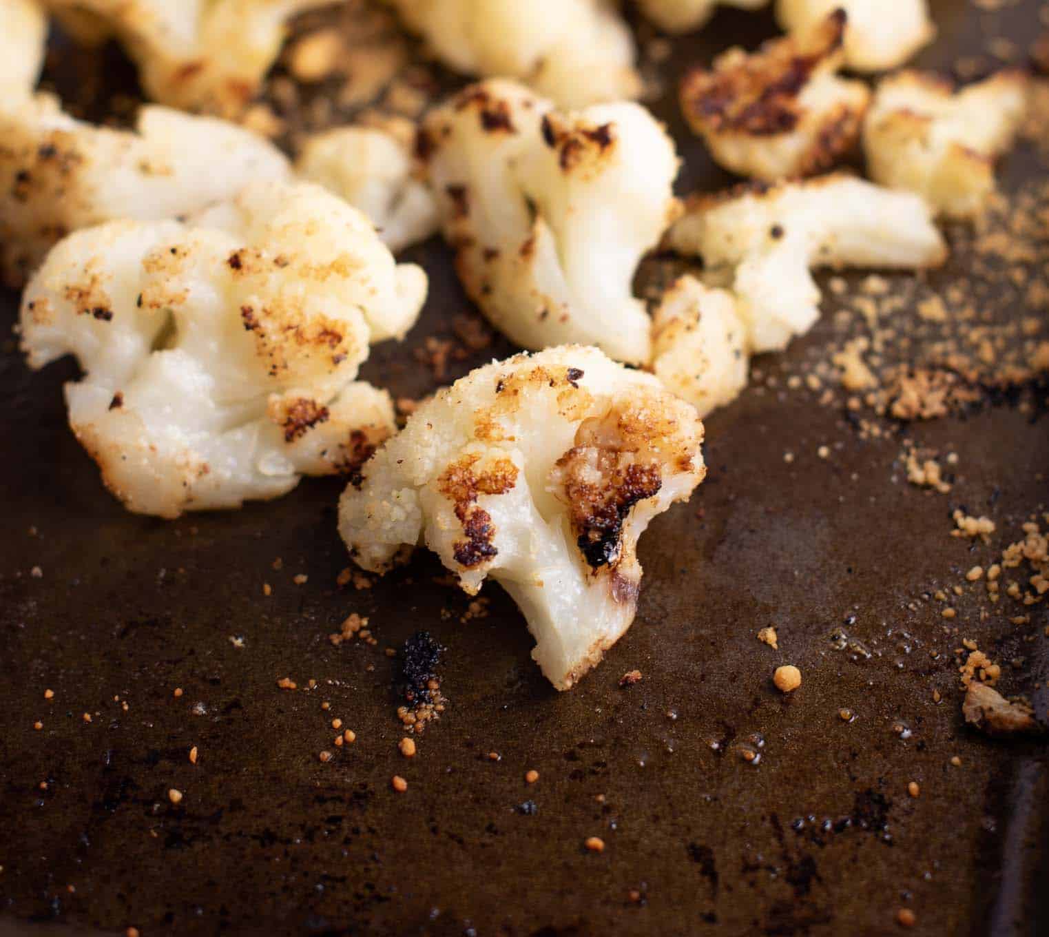 roasted frozen cauliflower on a brown baking sheet