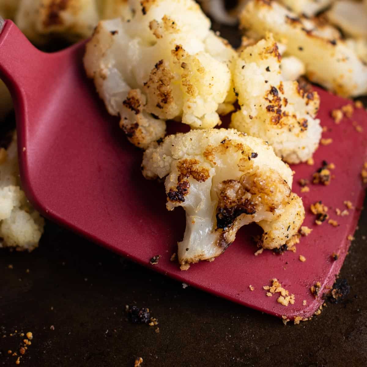 a red spatula with roasted frozen cauliflower on it