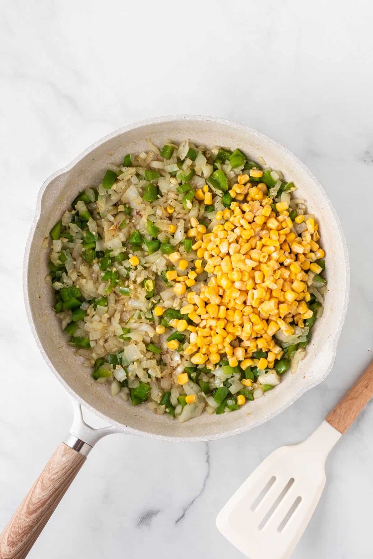 adding corn to the skillet