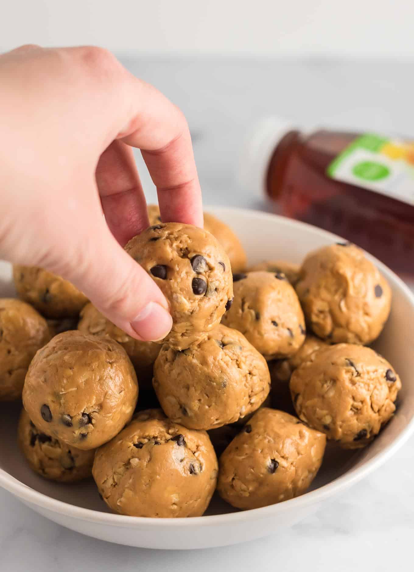 fingers taking an energy ball from the stacked bowl