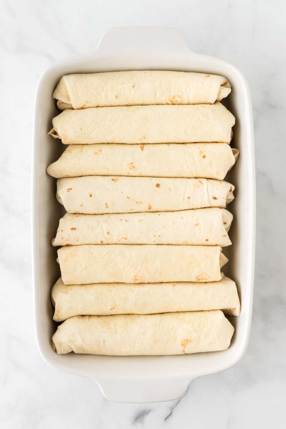 rolled up enchiladas in a baking dish