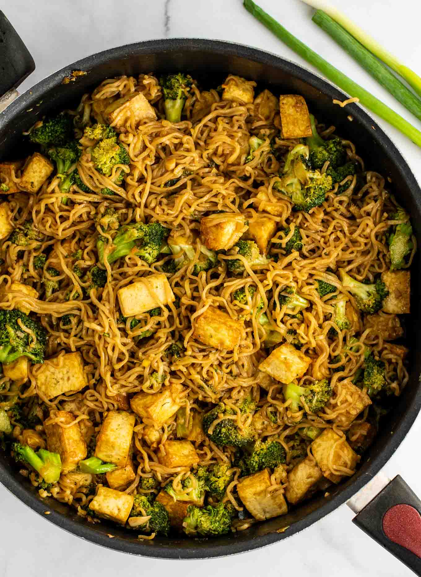 ramen noodles in a skillet with tofu and broccoli