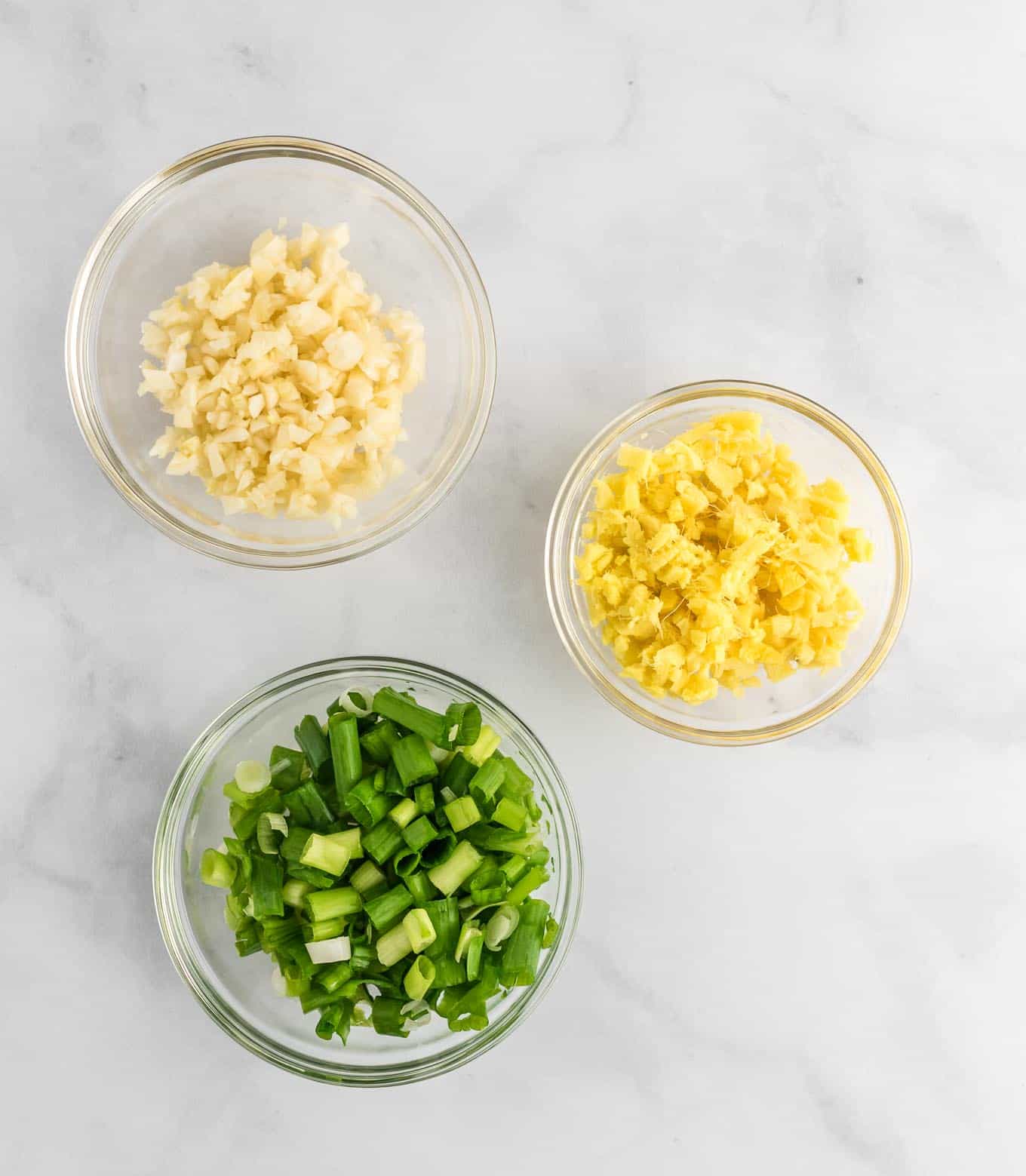 green onions, minced ginger, and minced garlic in clear bowls