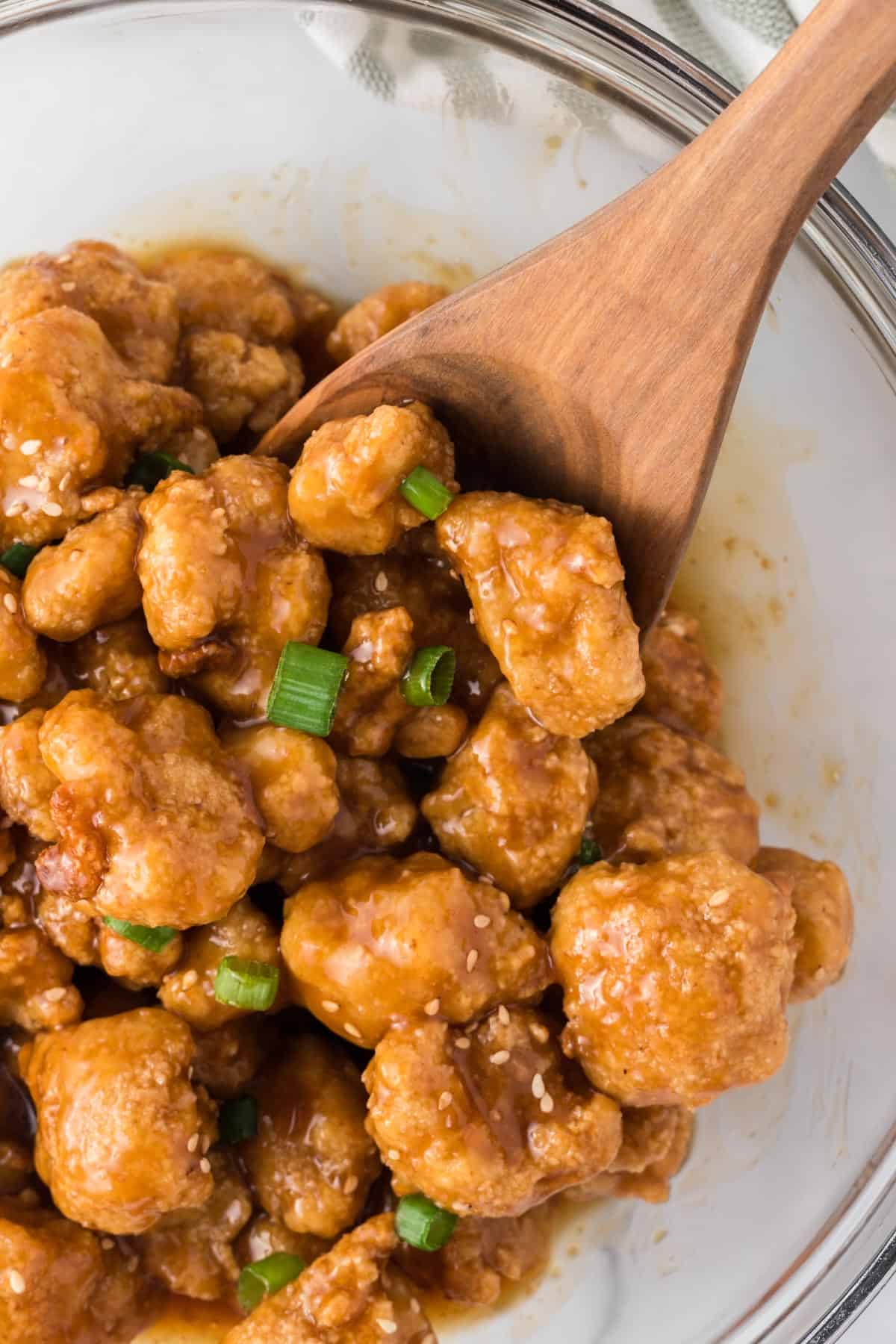 a wooden spoon stirring the cauliflower