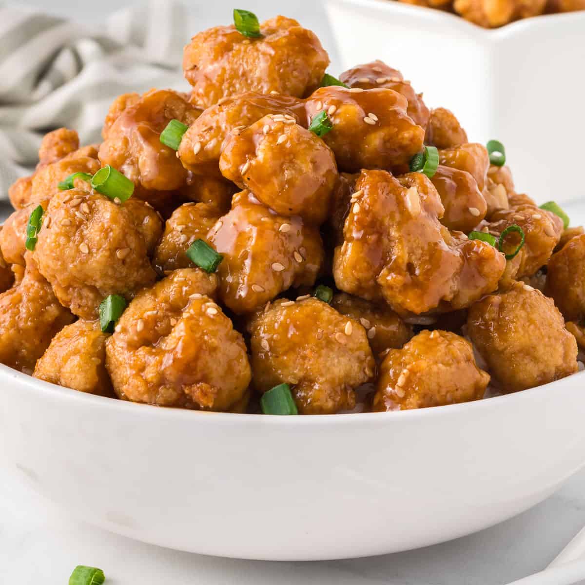 orange cauliflower in a bowl topped with green onions