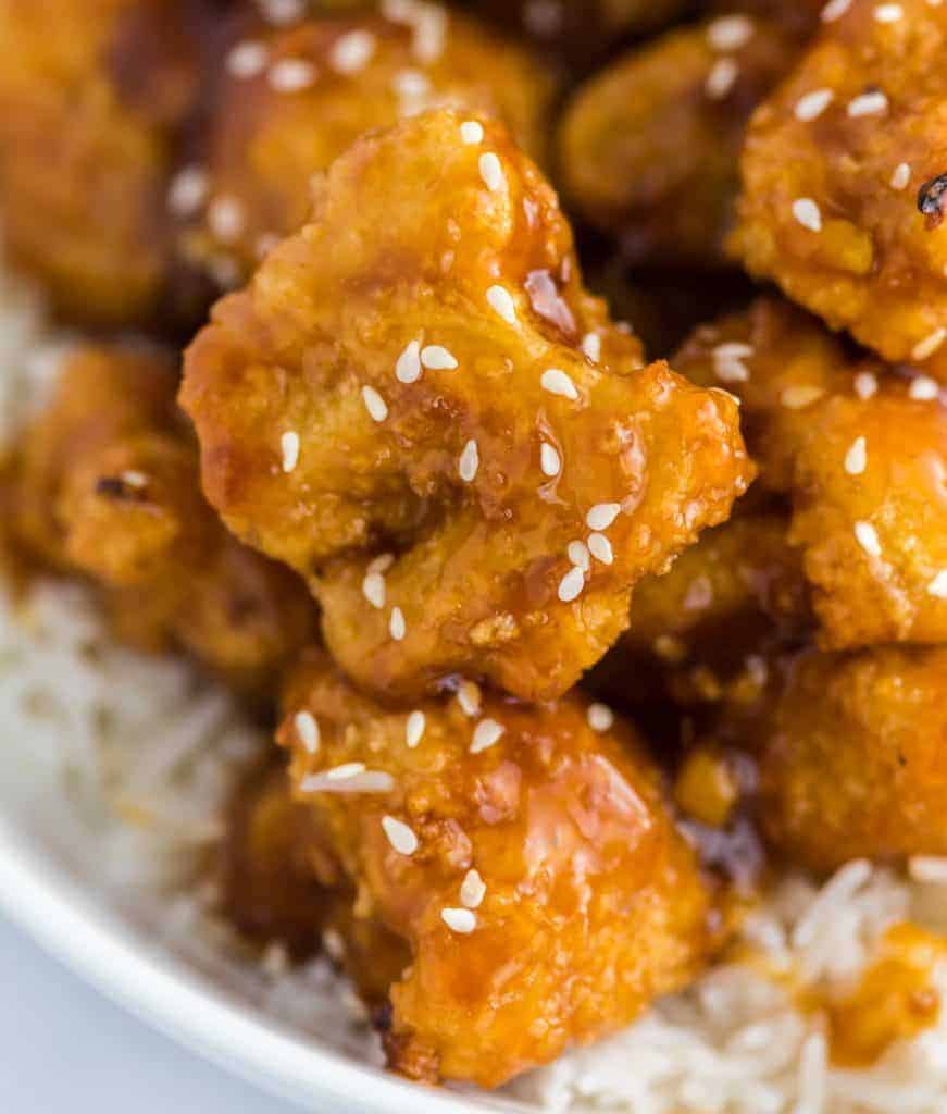 orange cauliflower with white sesame seeds sprinkled on top