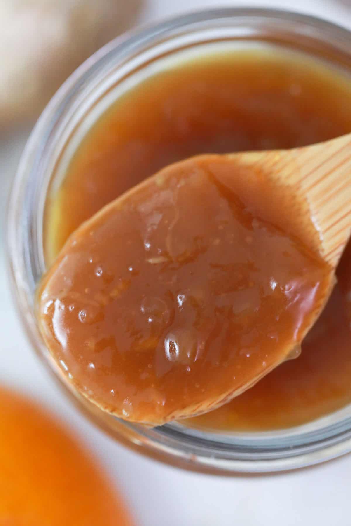 chinese orange sauce on a wooden spoon