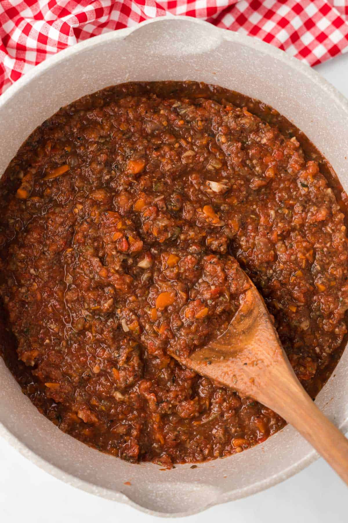 wooden spoon in a pot of vegetarian bolognese sauce