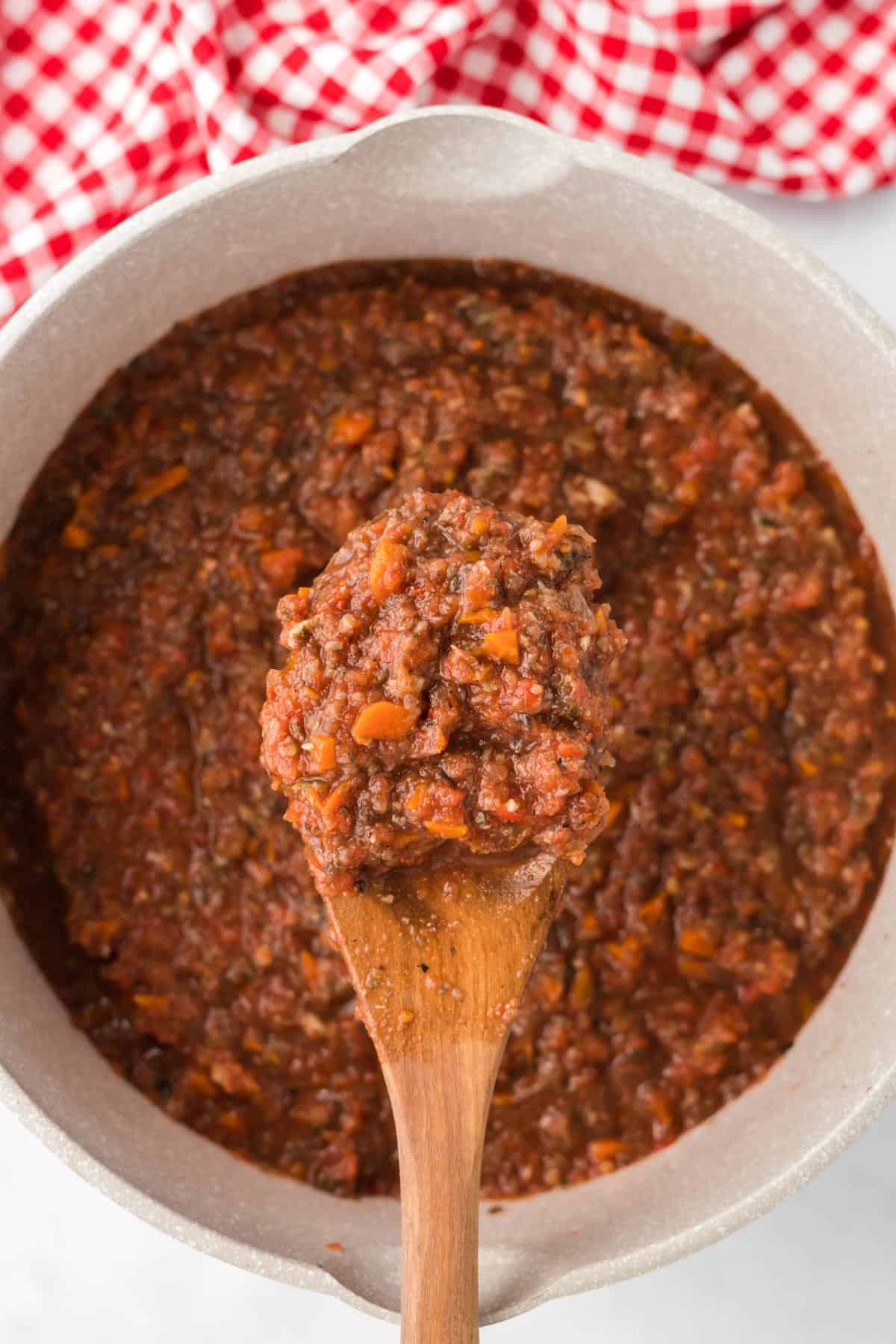 wooden spoon in a pot of vegetarian bolognese sauce