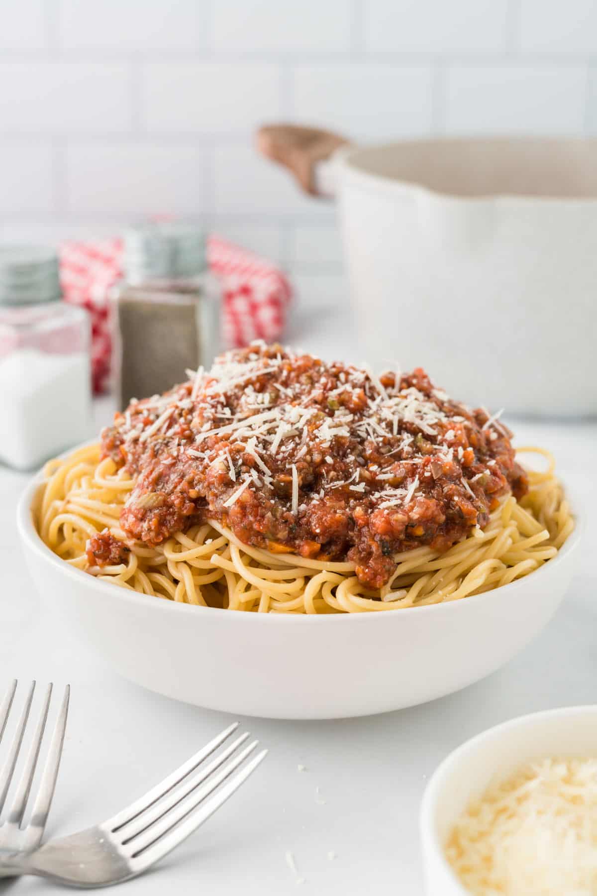 bowl of spaghetti topped with vegetarian bolognese sauce and parmesan cheese