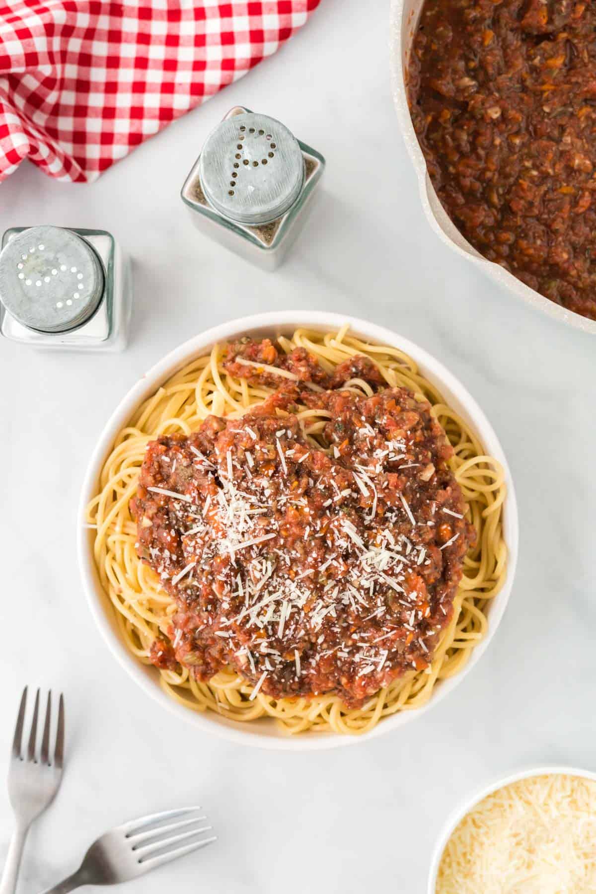 bowl of spaghetti topped with vegetarian bolognese sauce and parmesan cheese