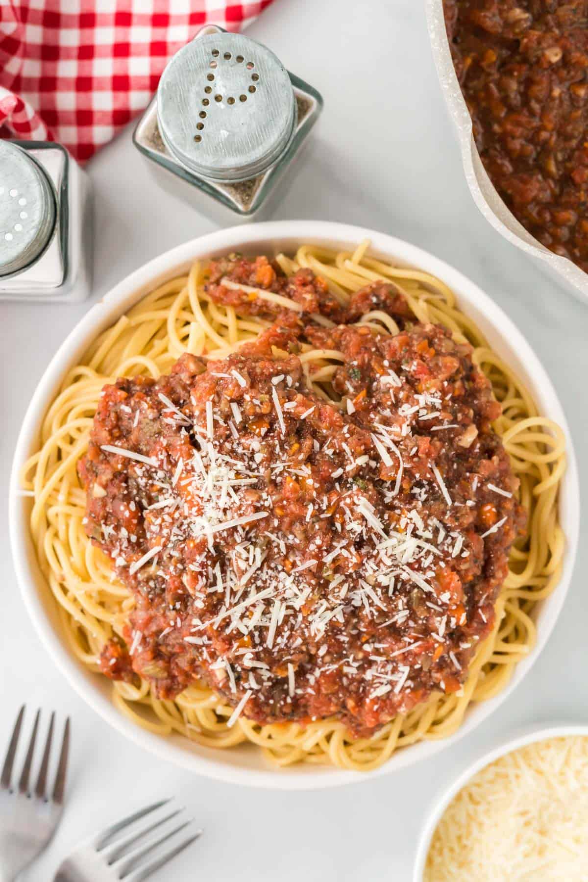 bowl of spaghetti topped with vegetarian bolognese sauce and parmesan cheese