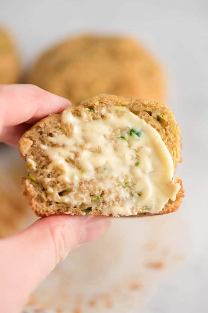 zucchini muffin cut in half with butter smeared on it